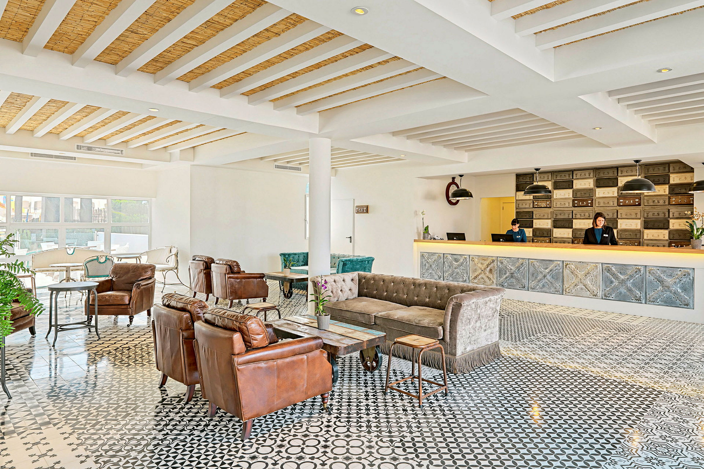 Hotellobby med bekväma sittmöbler, reception och dekorativt golv. (AI-genererad text)