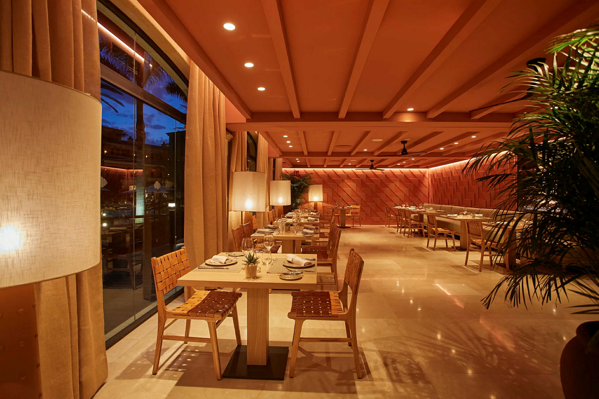 Interiör av en restaurang med moderna trämöbler och soft belysning. (AI-genererad text)