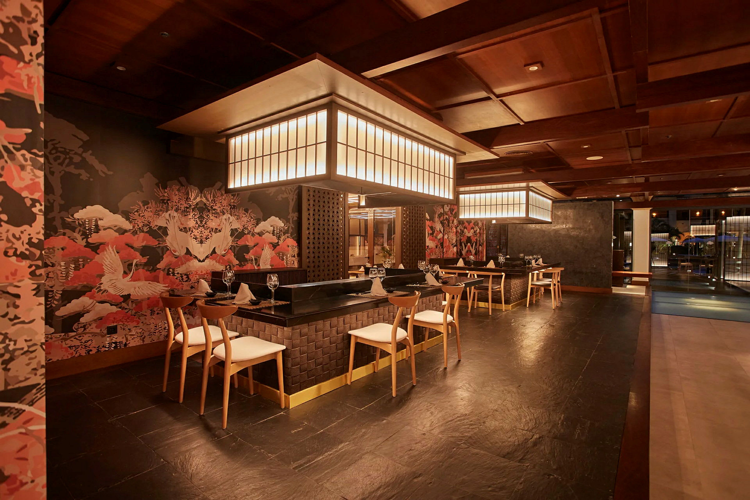 En interiör av en elegant restaurang med moderna möbler, stilfull belysning och väggar dekorerade med orientaliskt inspirerad konst. (AI-genererad text)