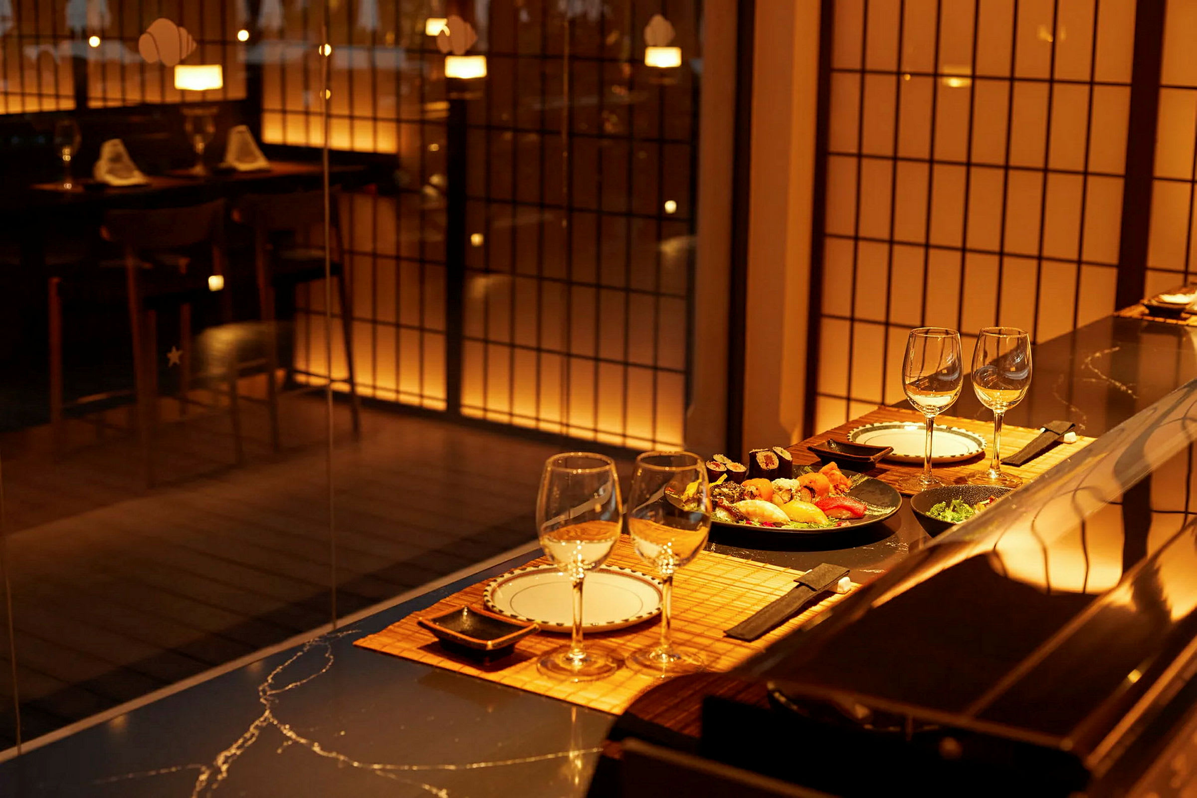 En elegant restaurang med dukat bord och sushi som serveras, belyst med varm belysning. (AI-genererad text)