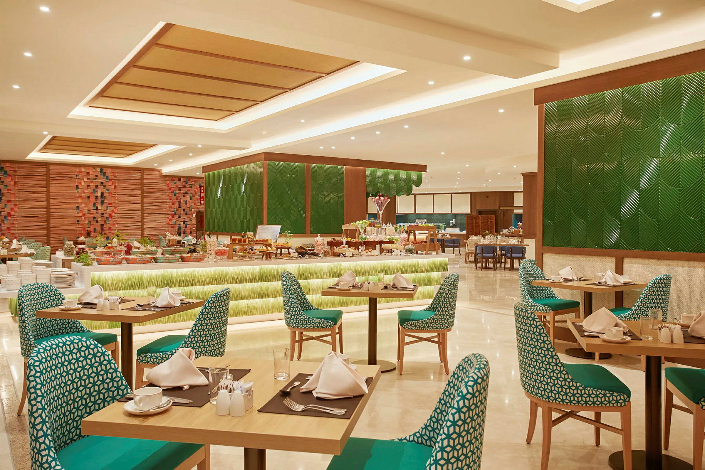 Interiör av en restaurang med dukade bord och stolar samt en buffé med mat i bakgrunden. (AI-genererad text)