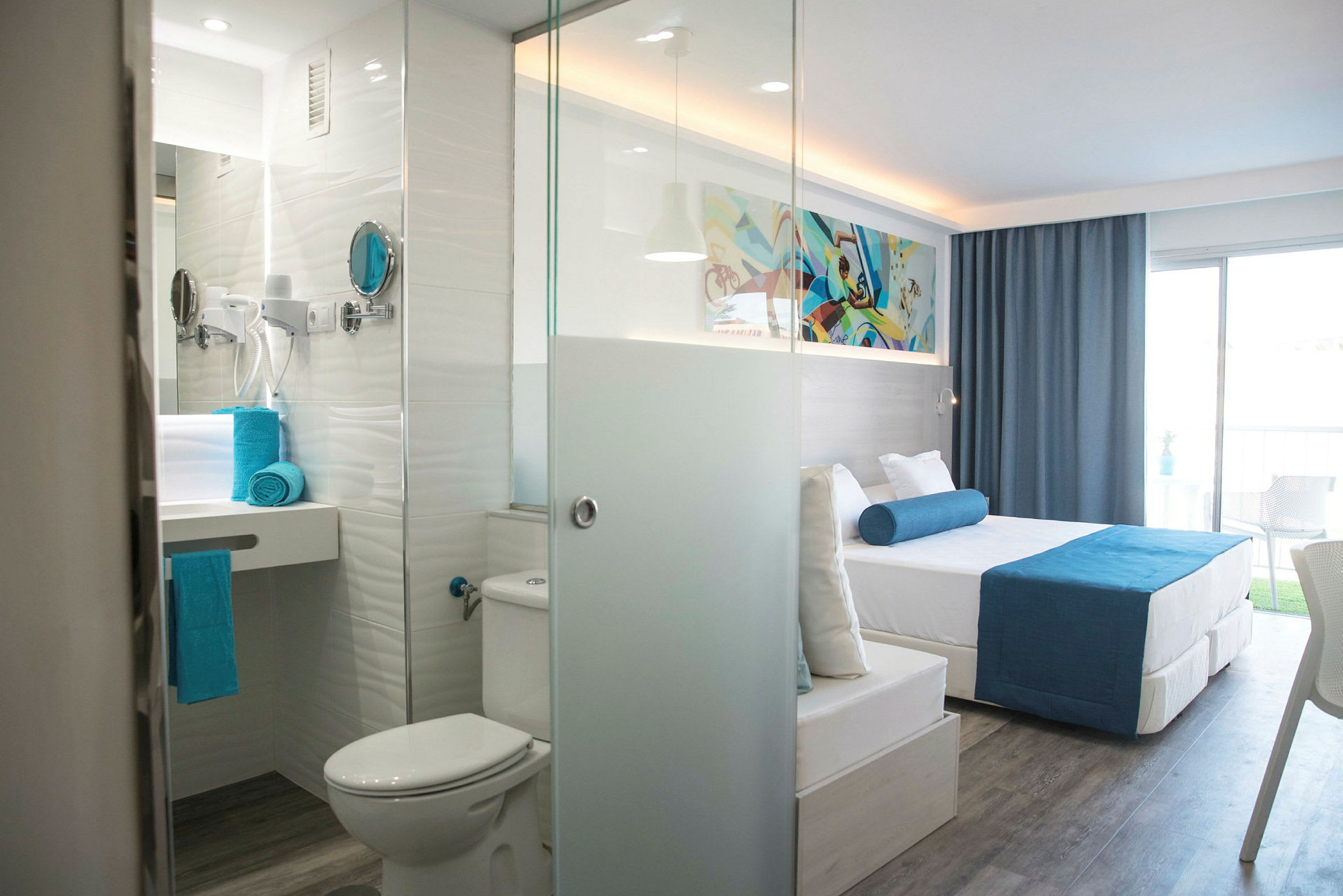 Modernt hotellrum med en säng, badrum och en balkong. (AI-genererad text)