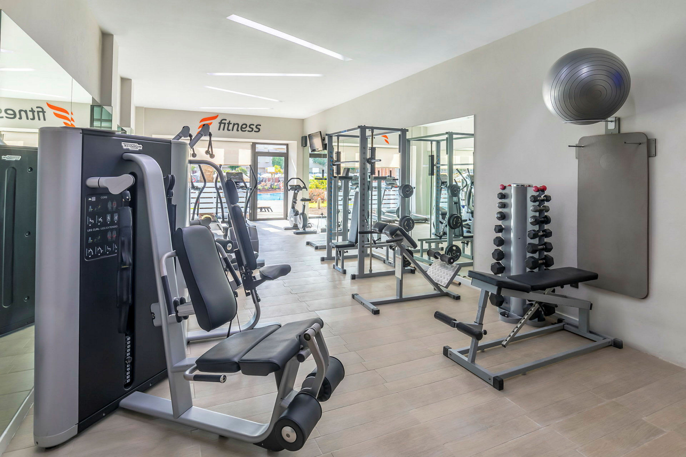 Bild av ett ljust gym med träningsutrustning och vikter. (AI-genererad text)