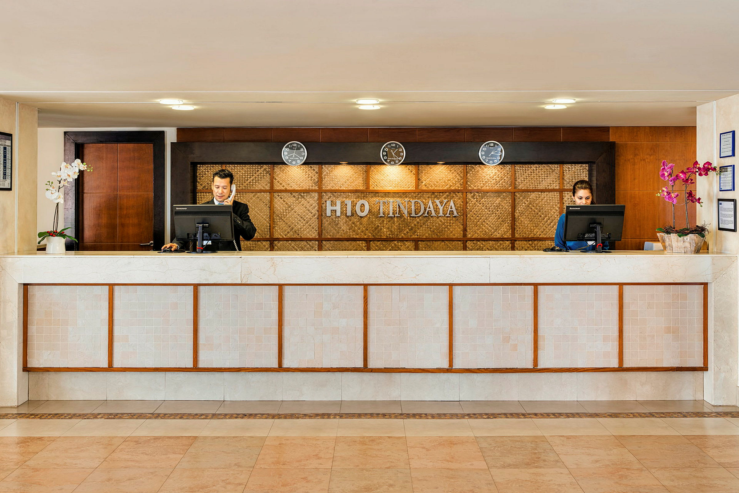 Receptionen på H10 Tindaya med två receptionsdiskar och personal. (AI-genererad text)