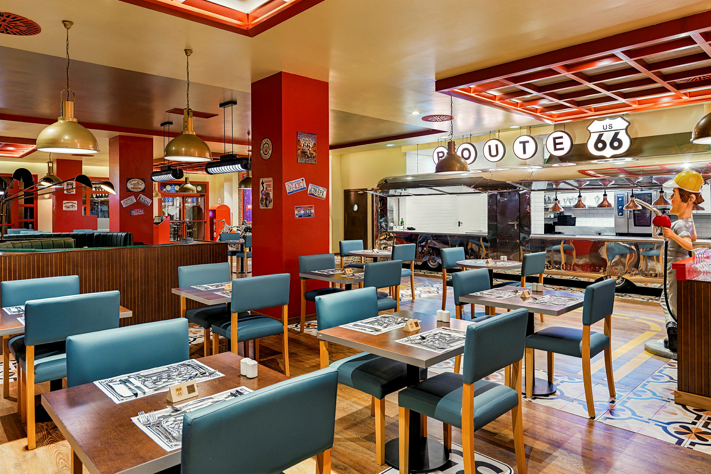 En restaurang inredd i amerikansk Route 66-stil med bord, blå stolar och en serveringsdisk. (AI-genererad text)