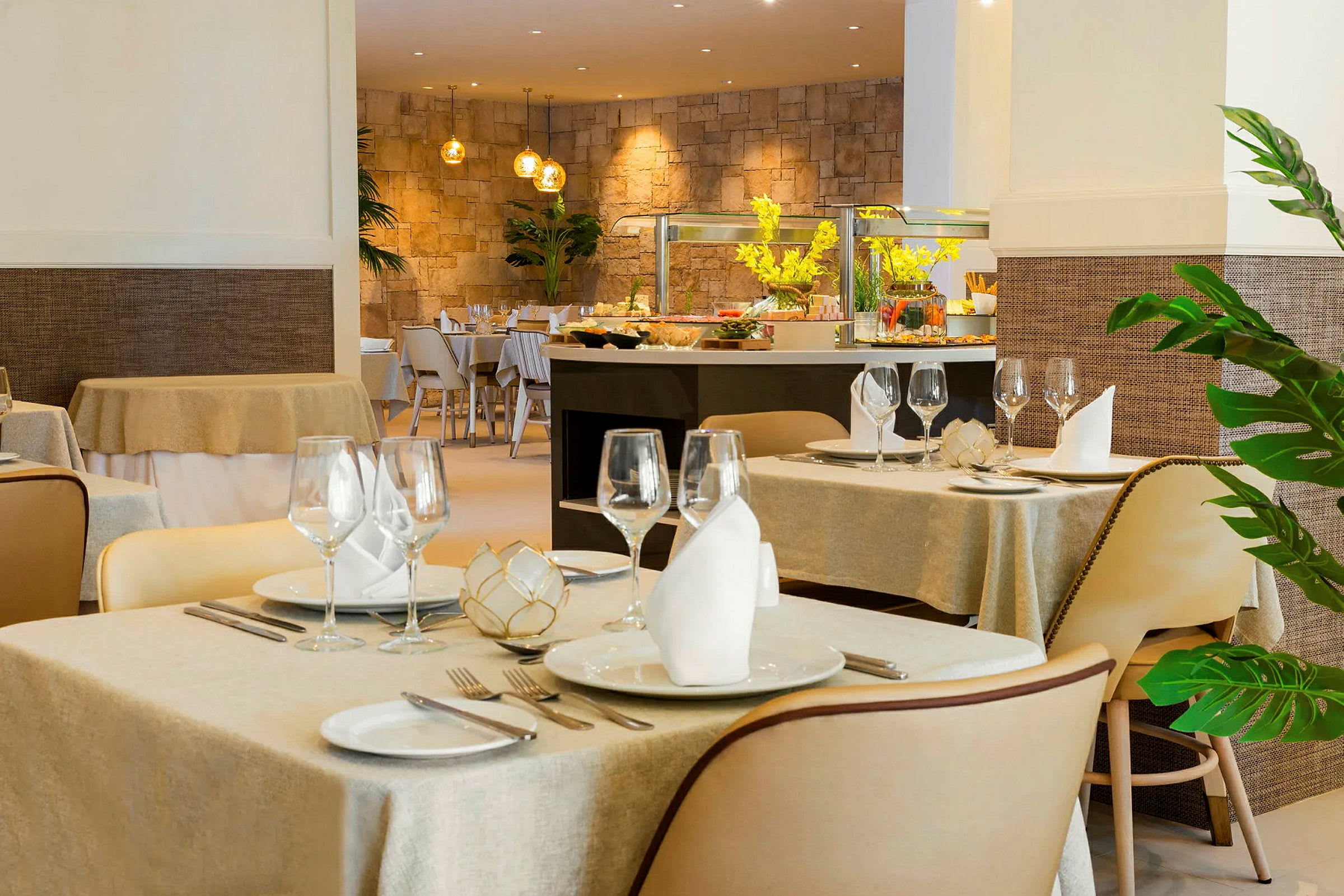 Interiör av en elegant restaurang med dukade bord och dekorerad buffédisk i bakgrunden. (AI-genererad text)