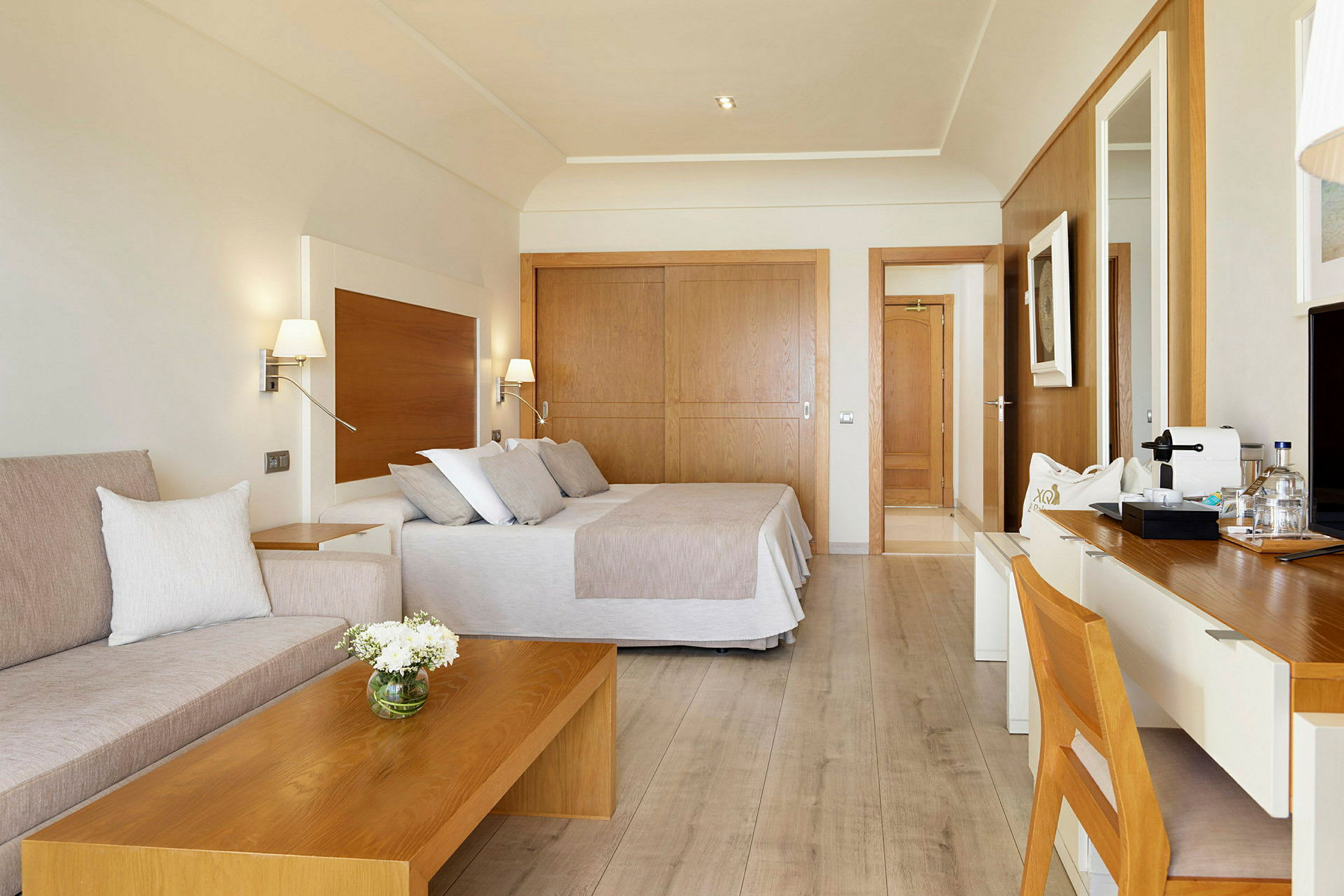 Ett hotellrum med modern inredning, säng, sittgrupp och skrivbord. (AI-genererad text)