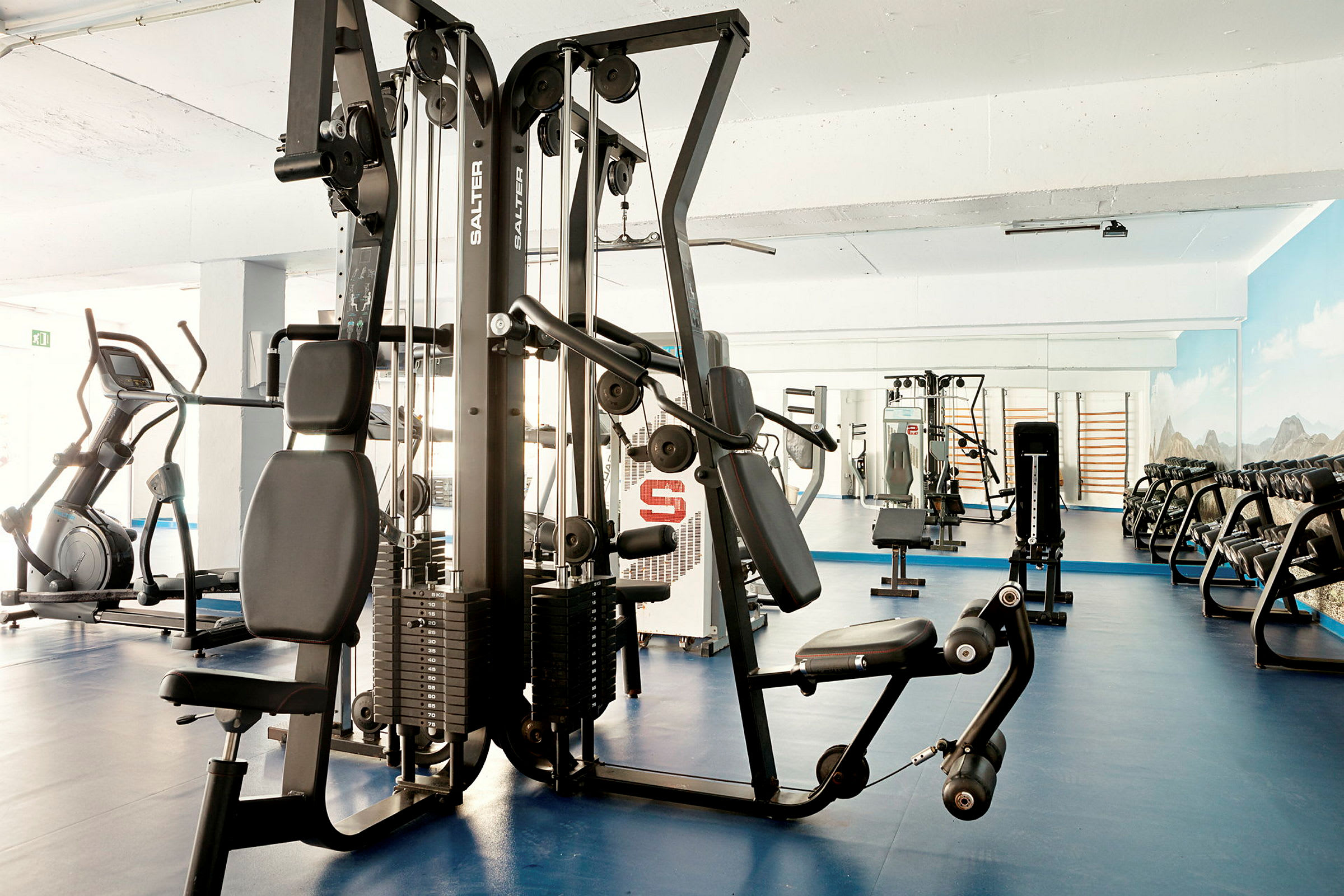 Ett gym med träningsmaskiner och fria vikter. (AI-genererad text)
