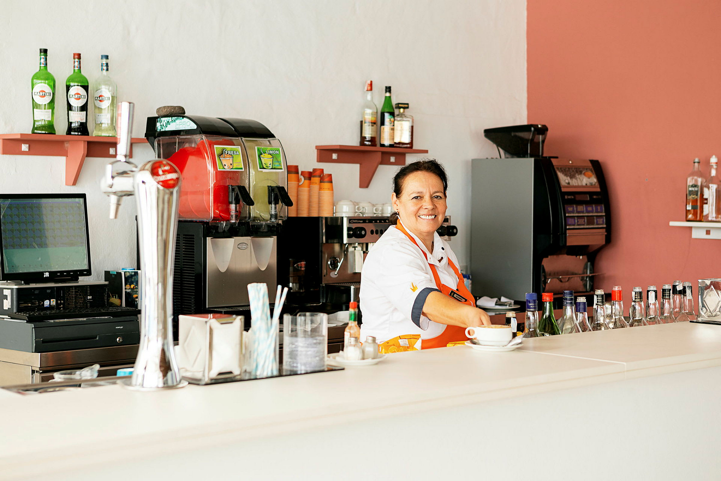 En kaffebar med maskiner, drycker och tillbehör på disken. (AI-genererad text)