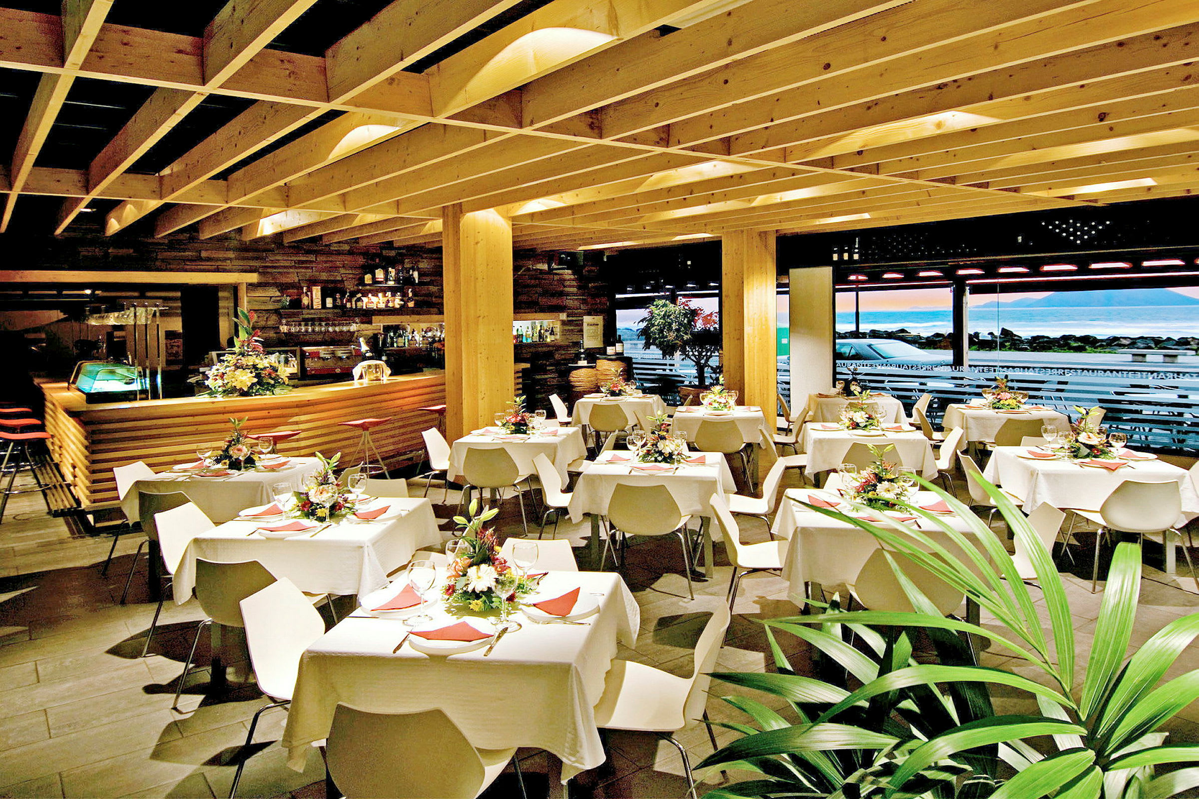 Restaurang interiör med dukade bord och dekorativa blommor. (AI-genererad text)