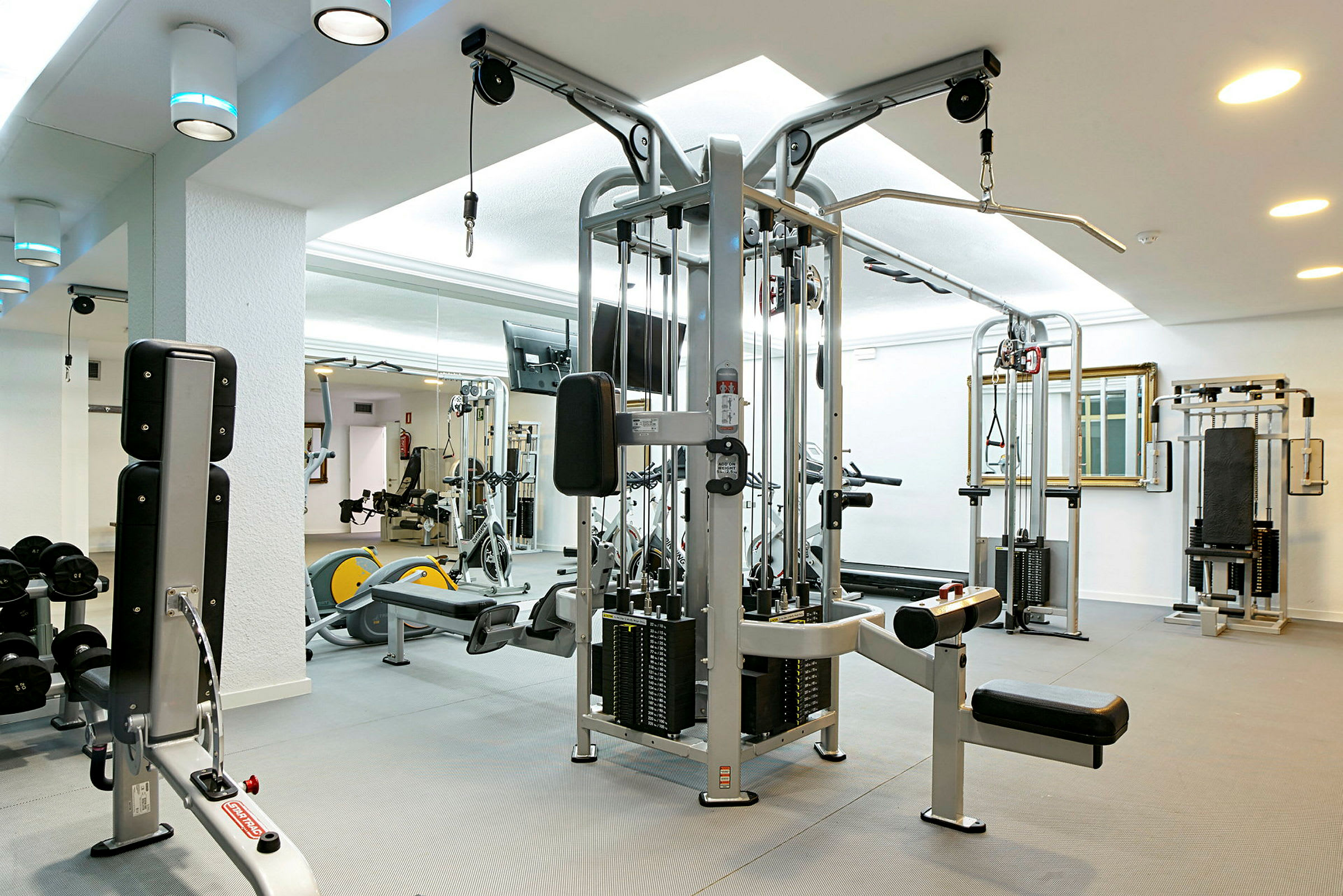 Ett gym med träningsmaskiner och fria vikter. (AI-genererad text)