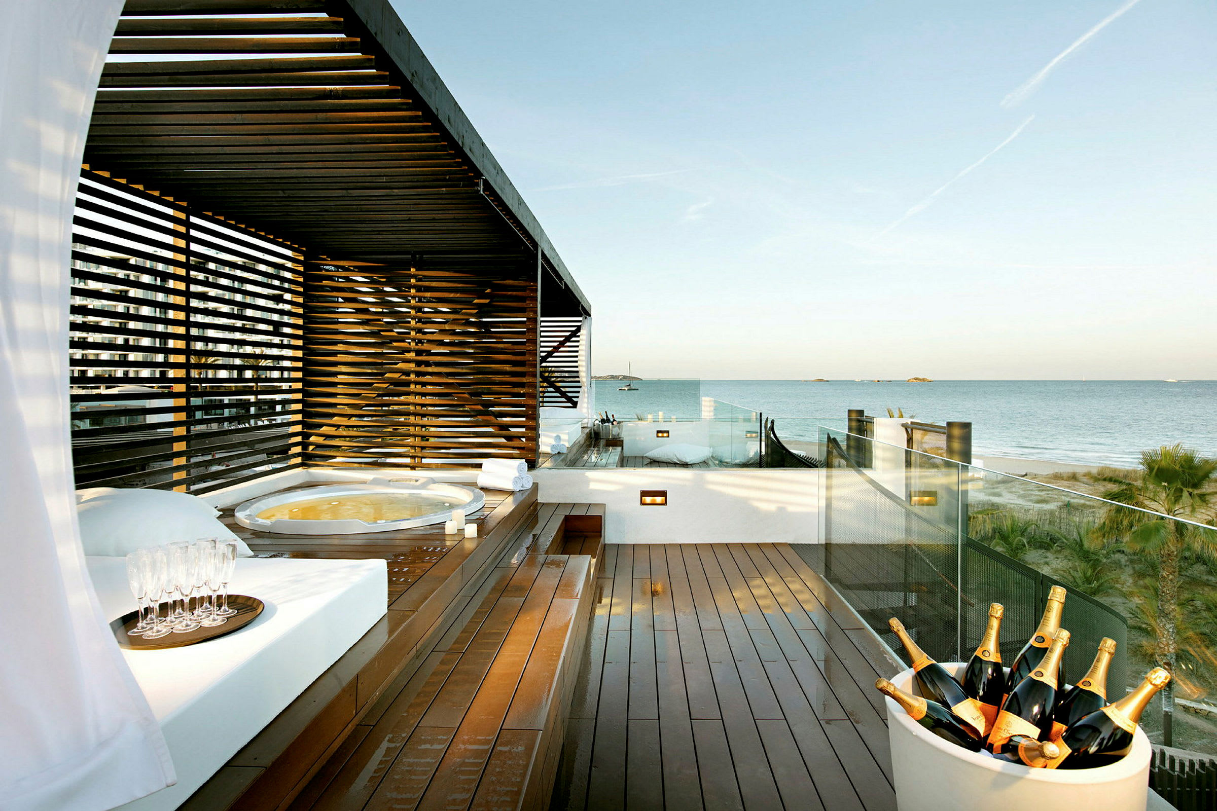 Terrass med jacuzzi, solstolar och utsikt över havet. (AI-genererad text)