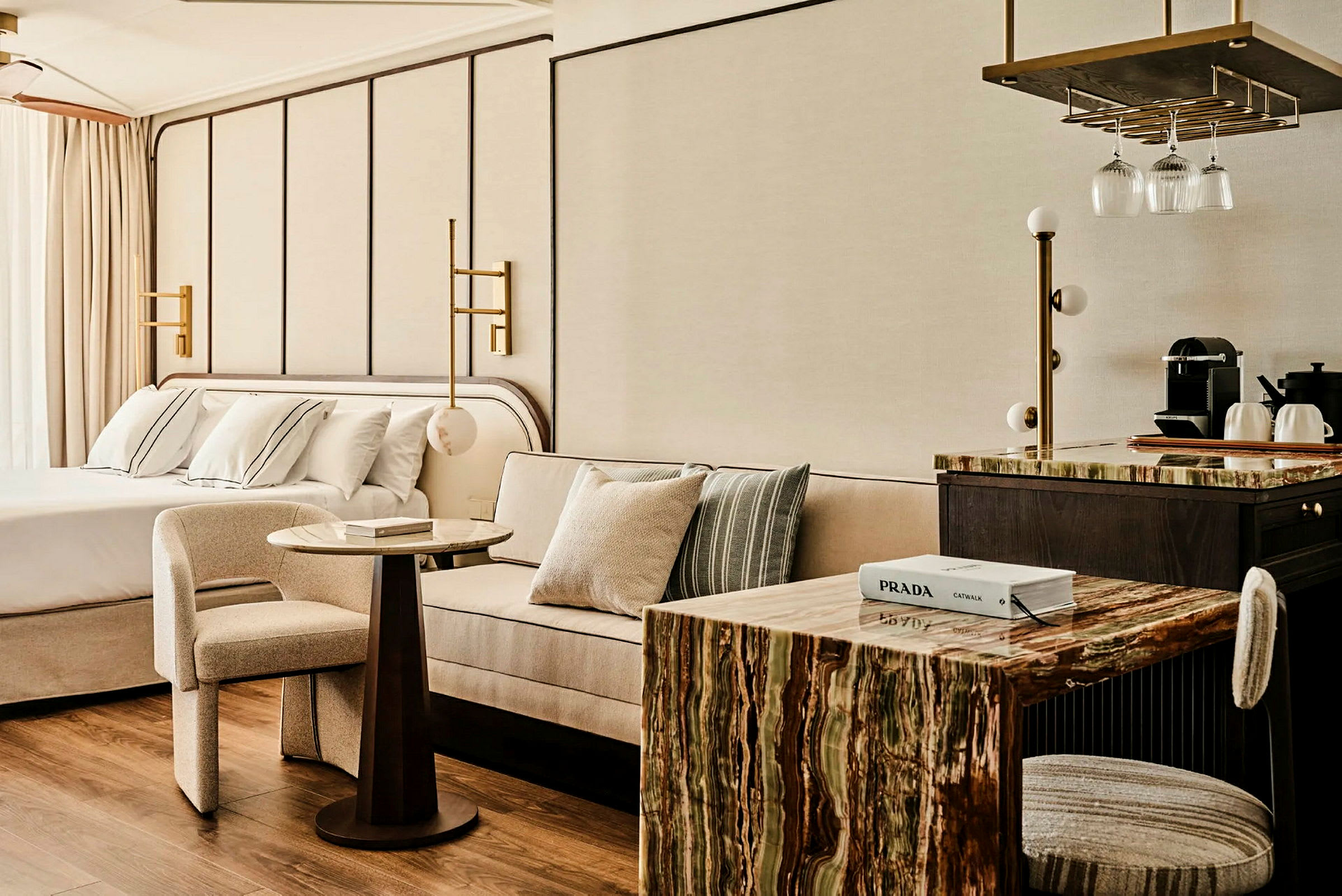 Ett modernt hotellrum med säng, soffa, bord och ett pentry. (AI-genererad text)
