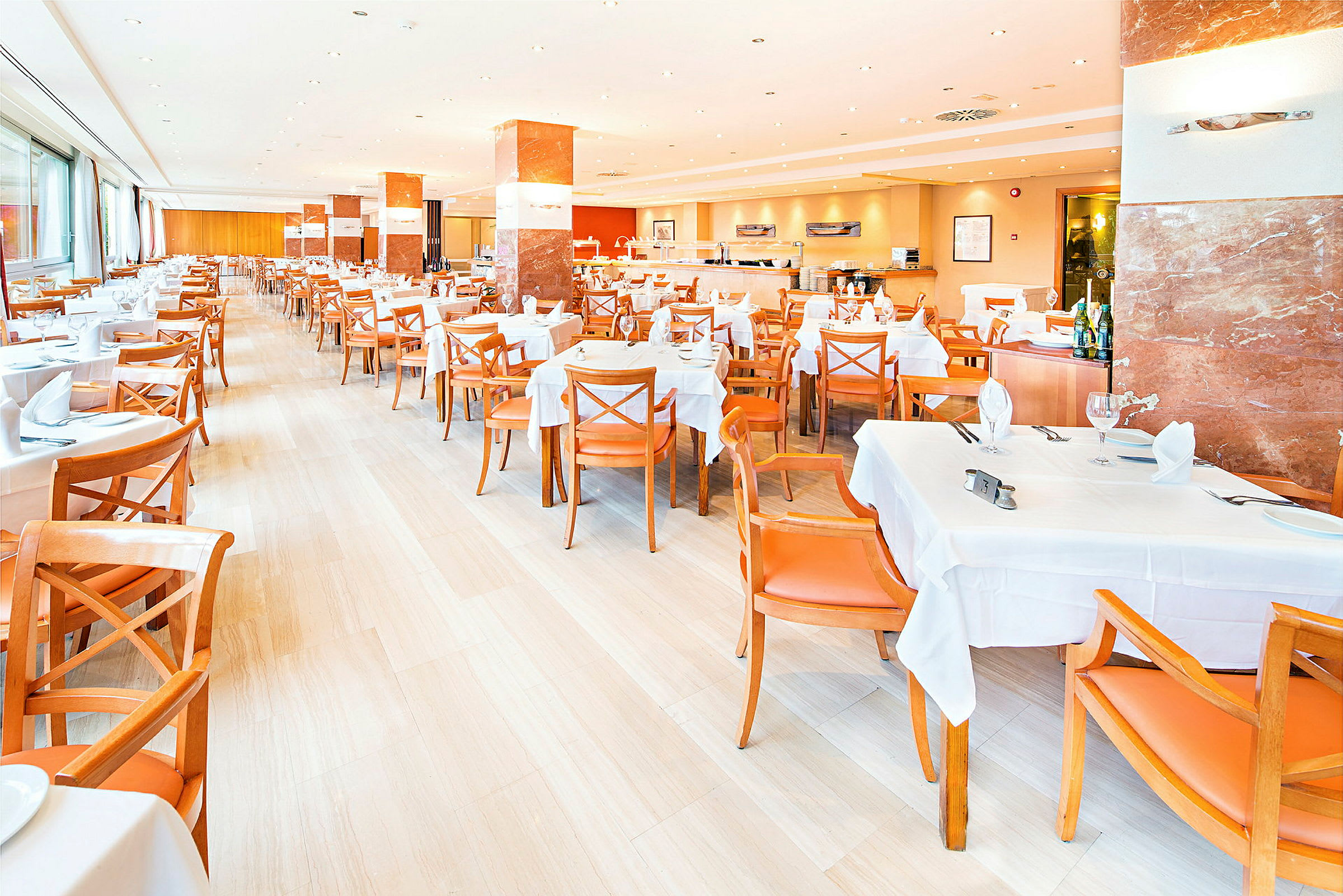 En ljus restaurang med vita bordsdukar och orange stolar, redo för gäster. (AI-genererad text)