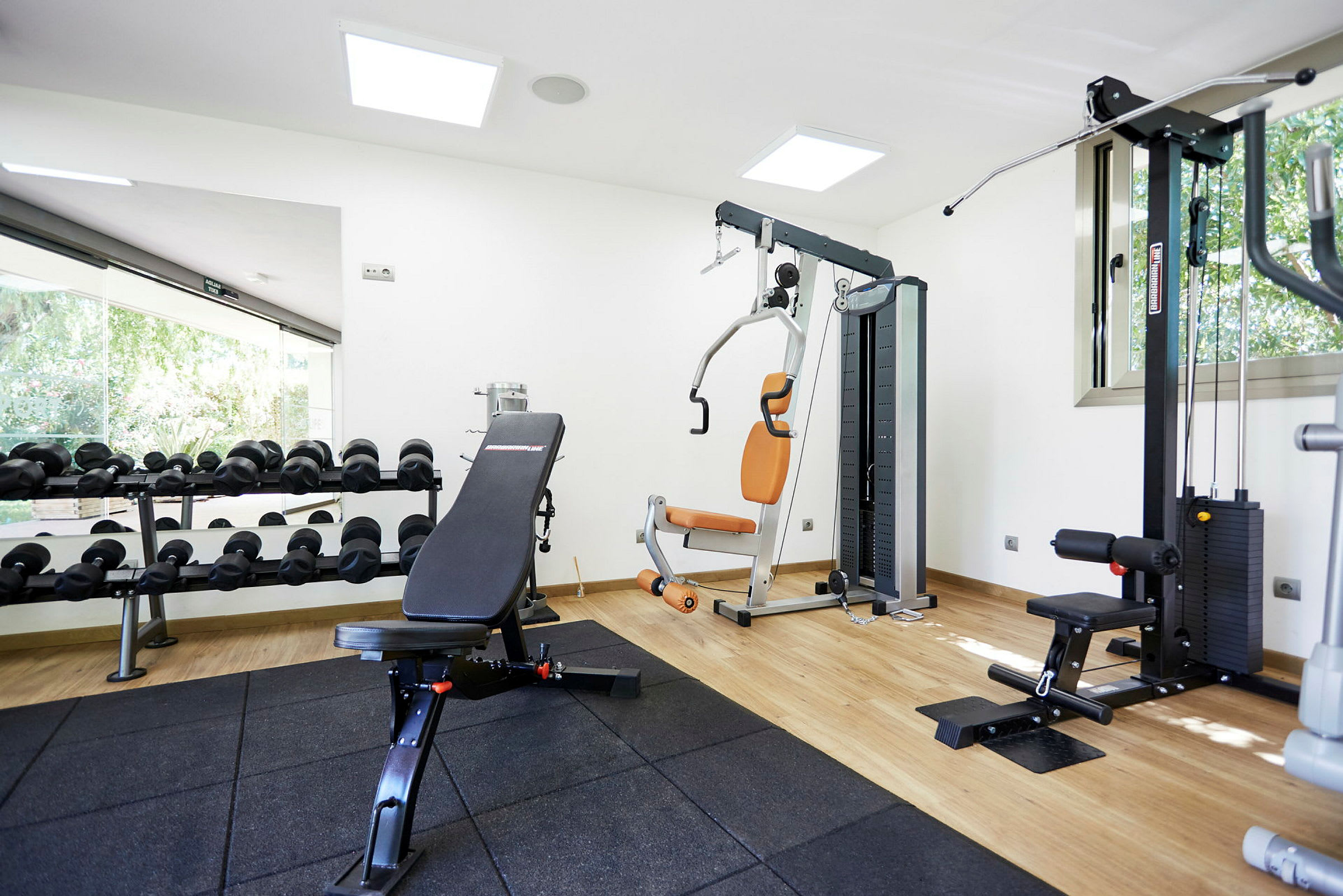 Ett gym med träningsutrustning såsom en viktbänk, hantlar och styrketräningsmaskiner. (AI-genererad text)