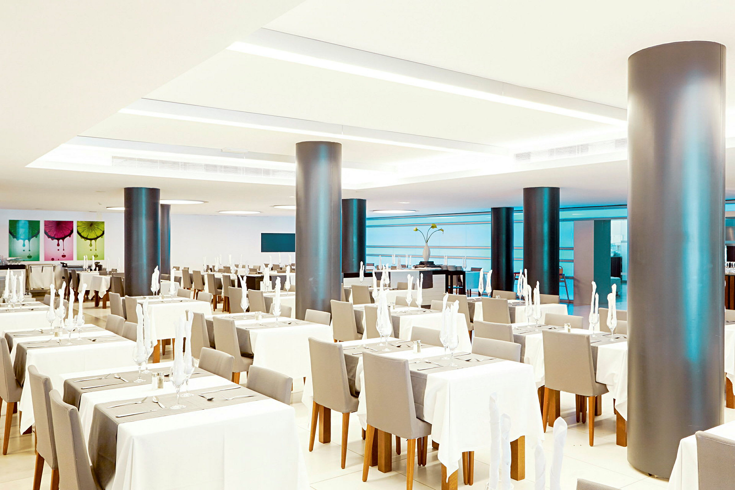 Ett modernt och ljust inrett restaurangområde med dukade bord och bekväma stolar. (AI-genererad text)