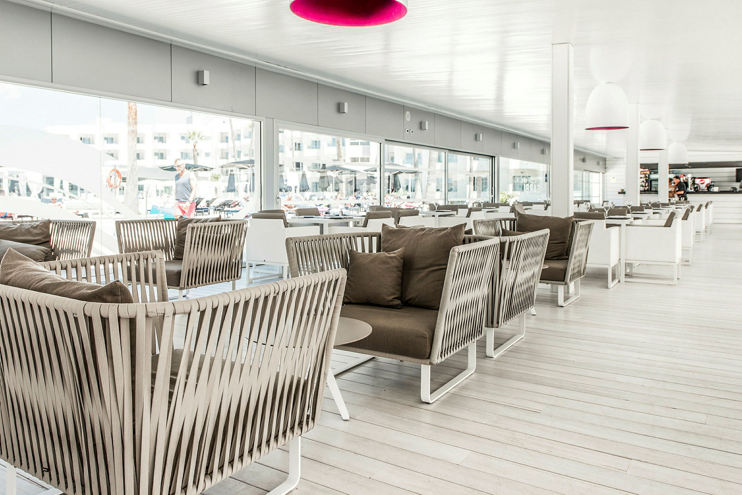 En modern inomhuslounge med bekväma rottingfåtöljer och bord. (AI-genererad text)