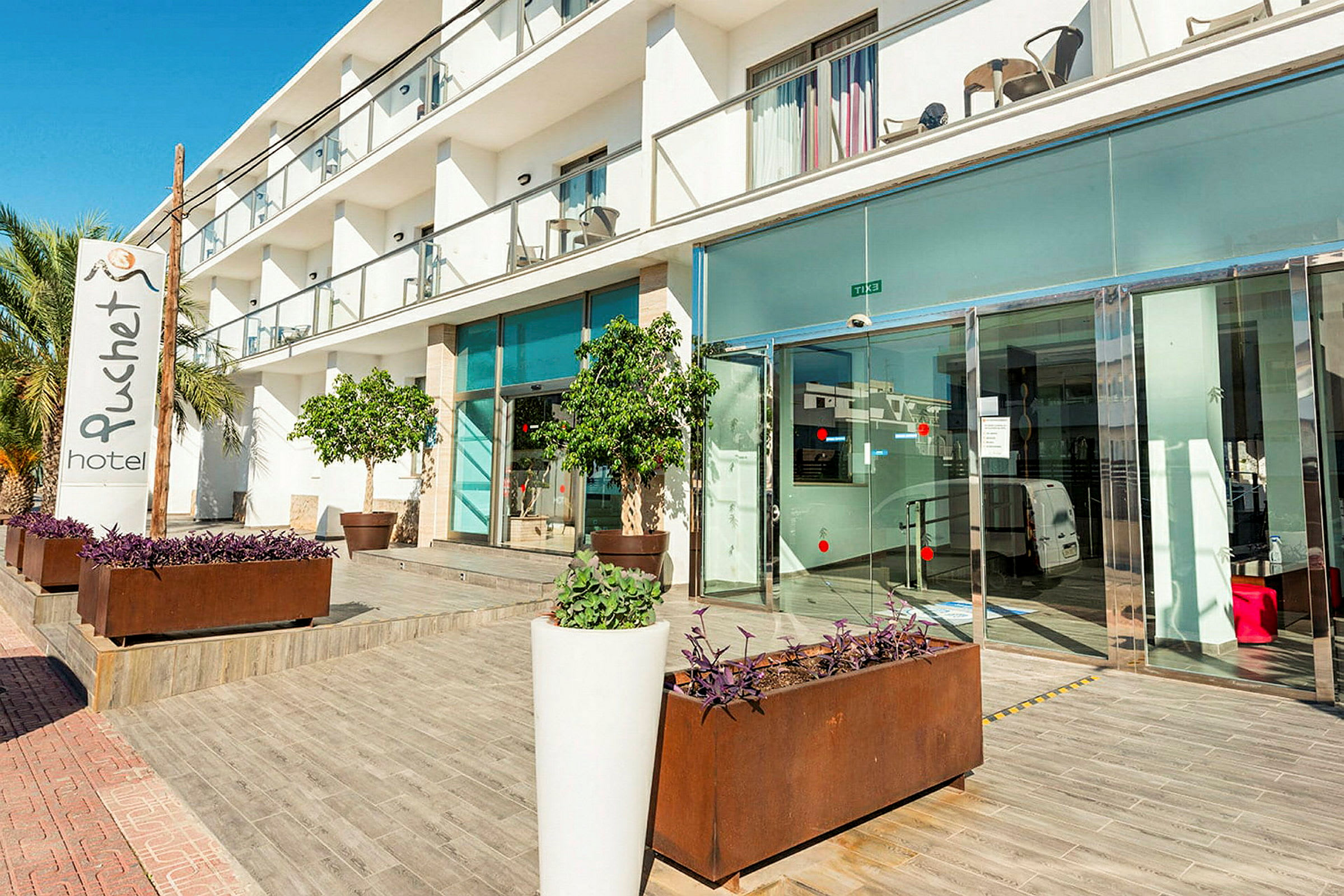 Hotellentré med glasdörrar och en skylt som visar hotellets namn. (AI-genererad text)