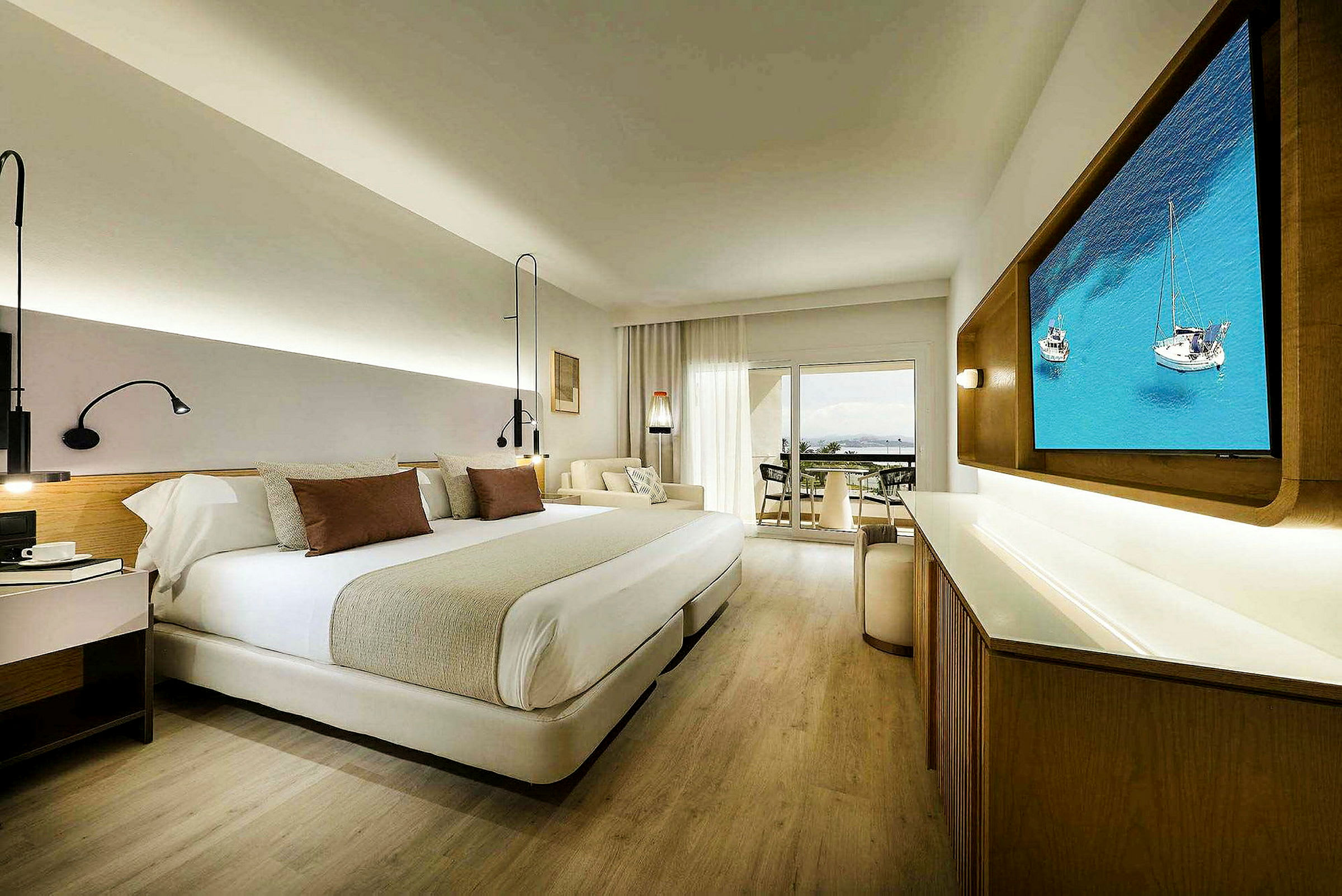 Ett modernt hotellrum med dubbelsäng, TV, sittgrupp och en balkong med utsikt. (AI-genererad text)