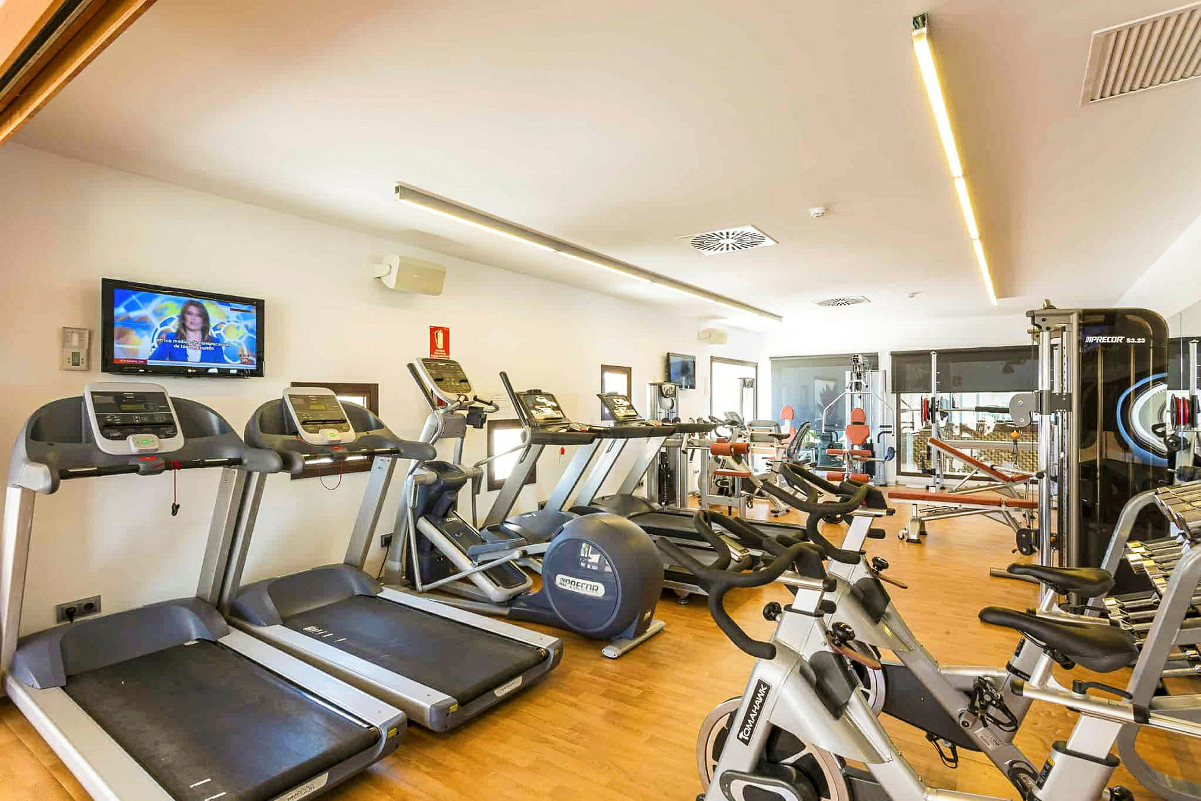 Gym med träningsmaskiner som löpband, motionscyklar och styrketräningsutrustning. (AI-genererad text)