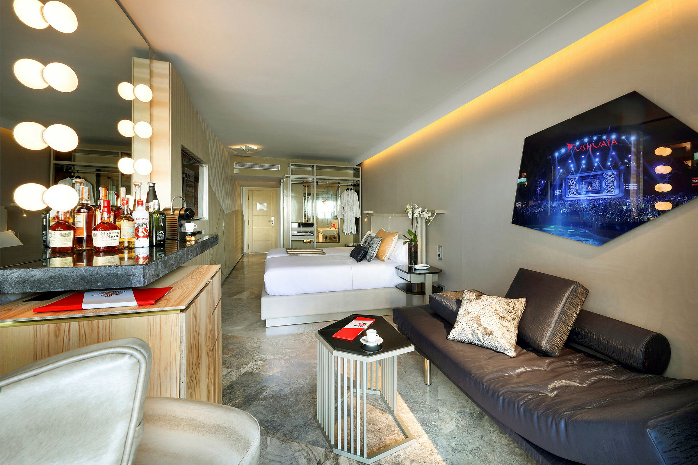 Bild av ett hotellrum med modern design, inklusive en bekväm säng, minibar, soffa och vägg-TV. (AI-genererad text)