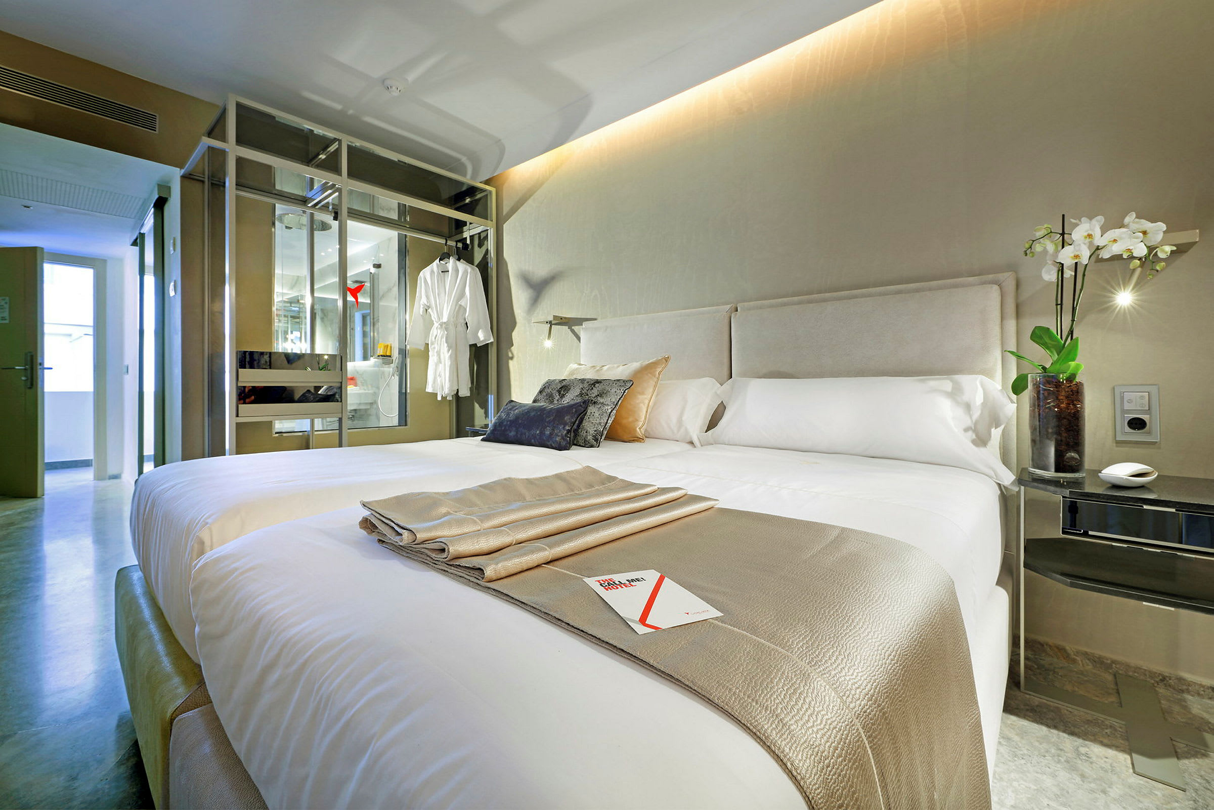 Bild av ett modernt hotellrum med en dubbelsäng, dekorativa kuddar, och en elegant inredd interiör. (AI-genererad text)