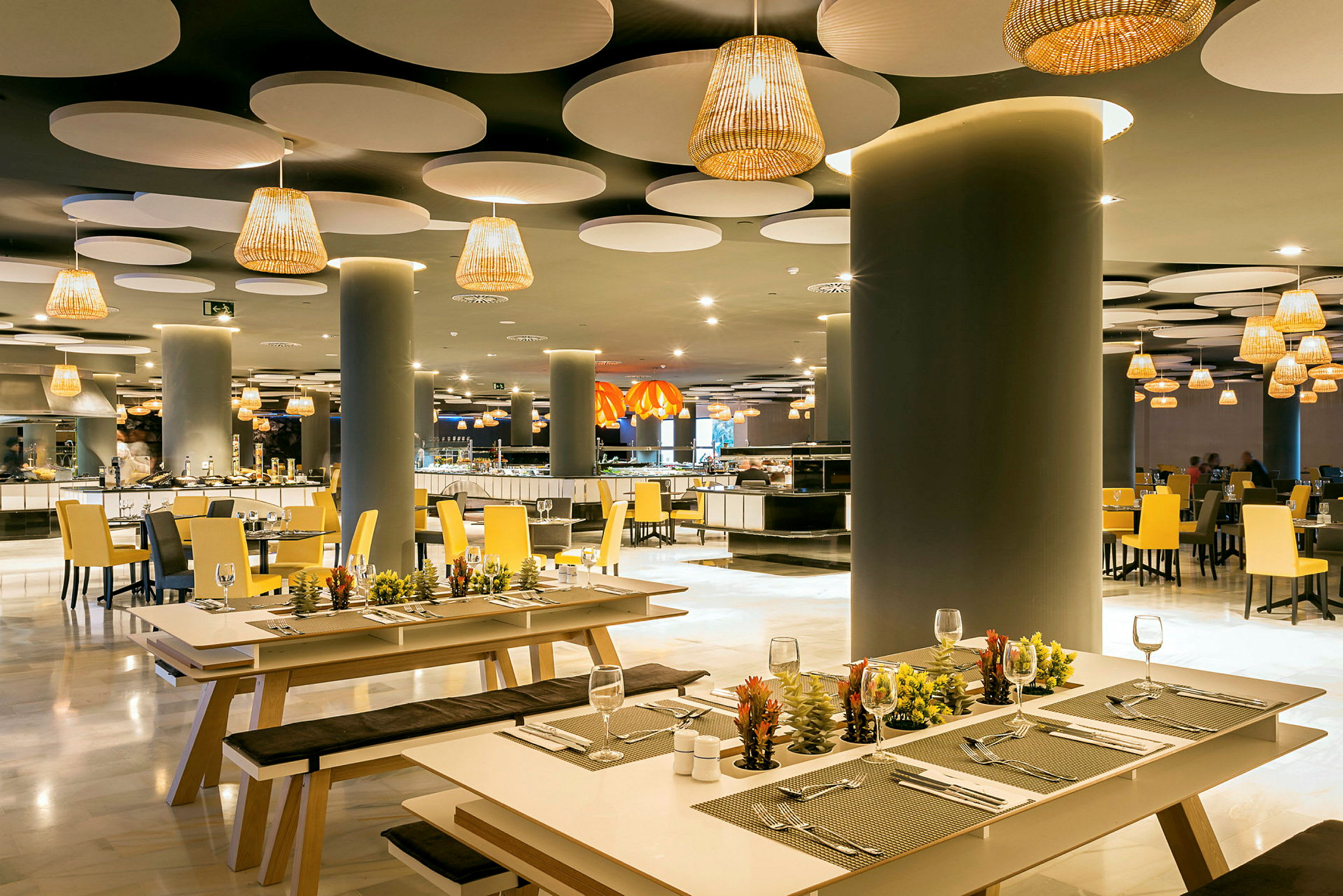Elegant restaurang med modern inredning, med bänkar och bord dekorerade med små växter. (AI-genererad text)