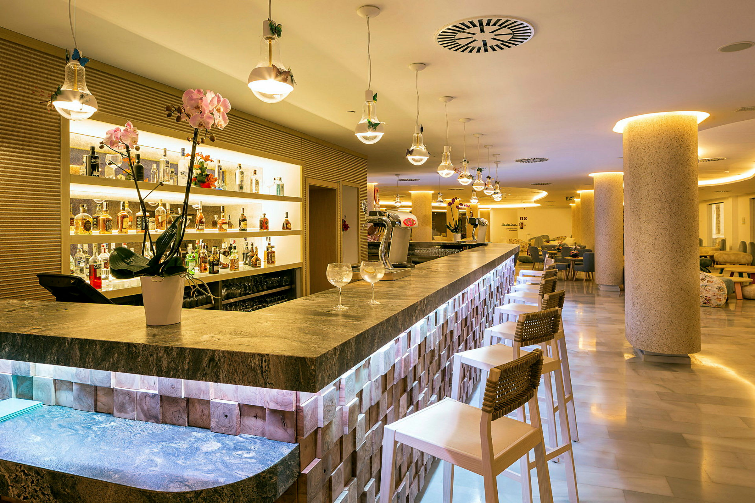 Interiör av en elegant bar med bardisk, stolar och flaskor uppställda på hyllor. (AI-genererad text)