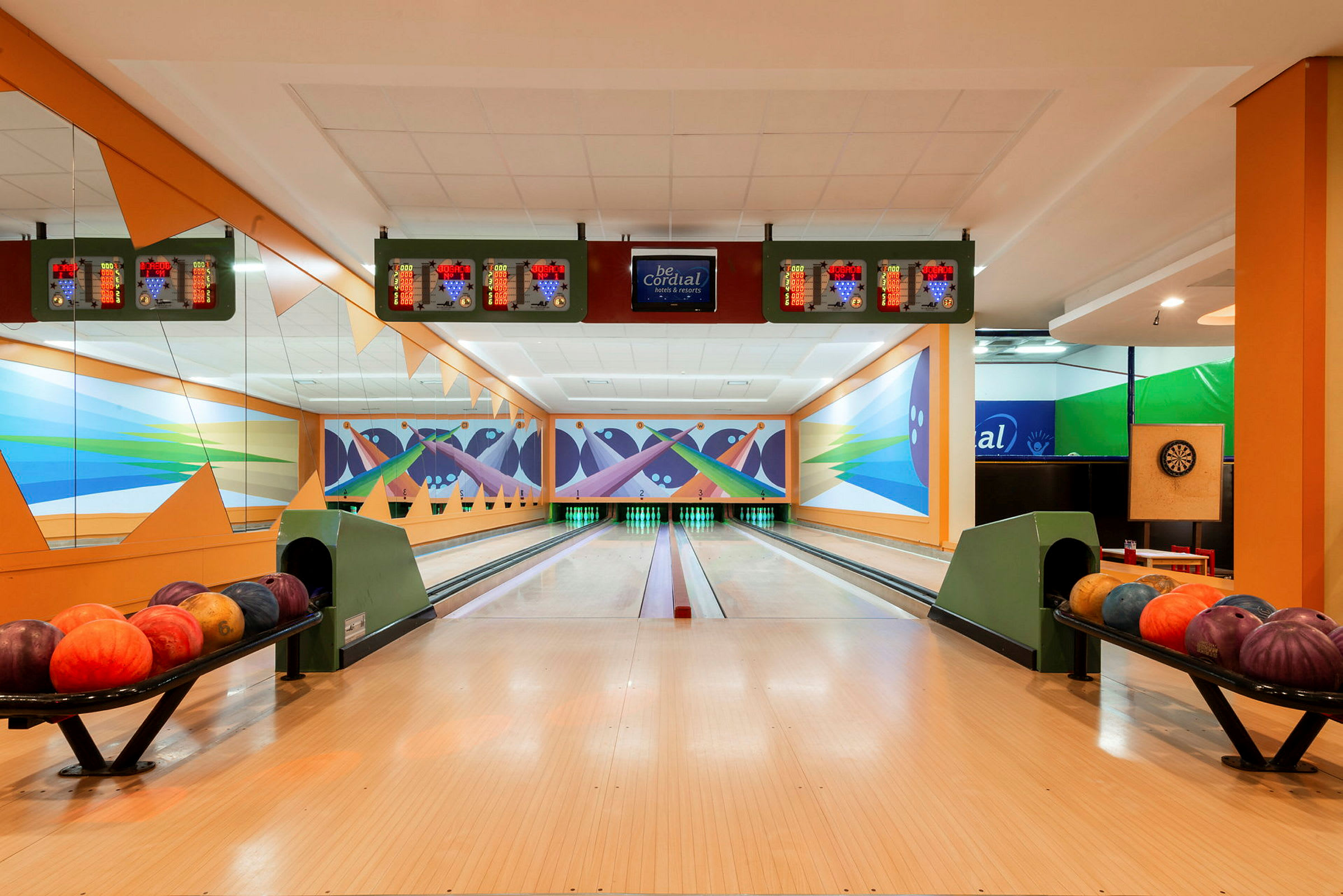 En bowlinghall med två bowlingbanor och bowlingklot på stativ. (AI-genererad text)