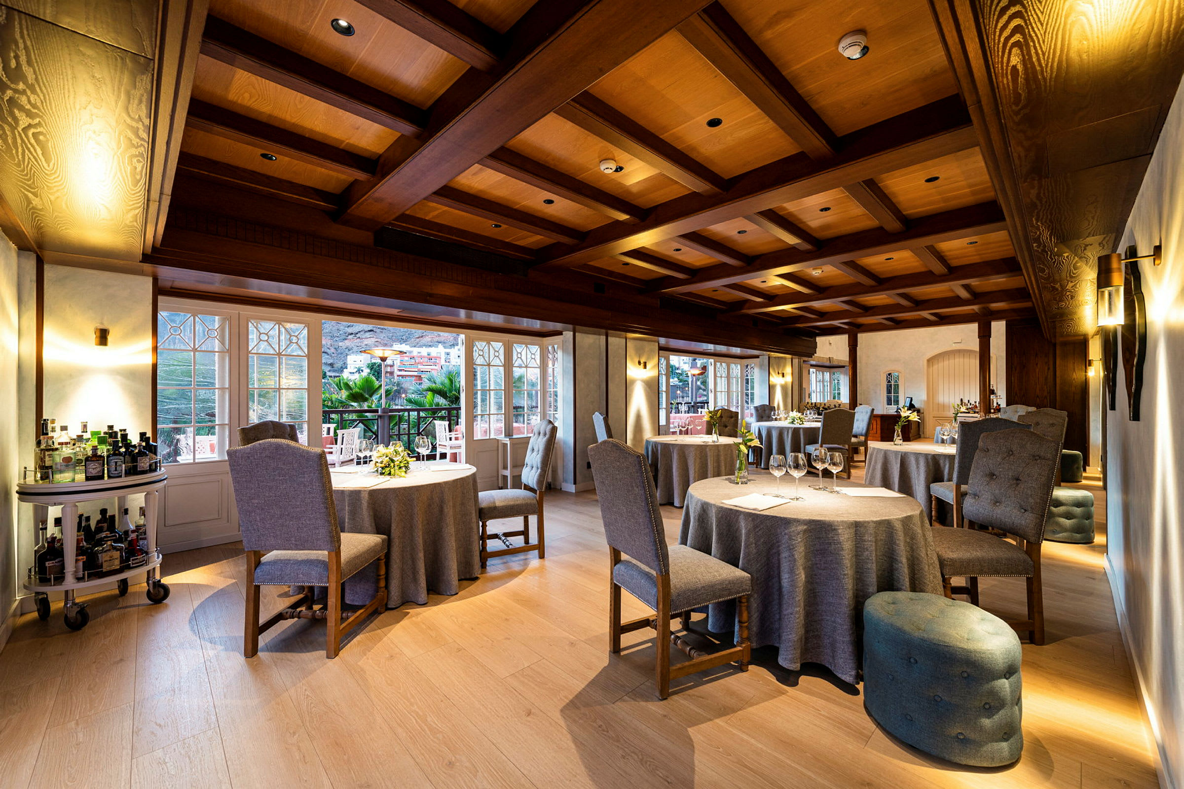 Restaurangrum med dukade bord och fönster som vetter mot en terrass. (AI-genererad text)