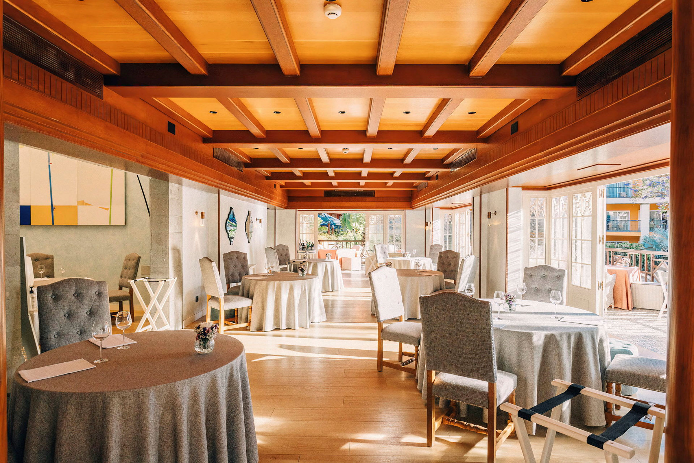 Restaurang med dukade bord och stolar, trädetaljer på tak och golv. (AI-genererad text)