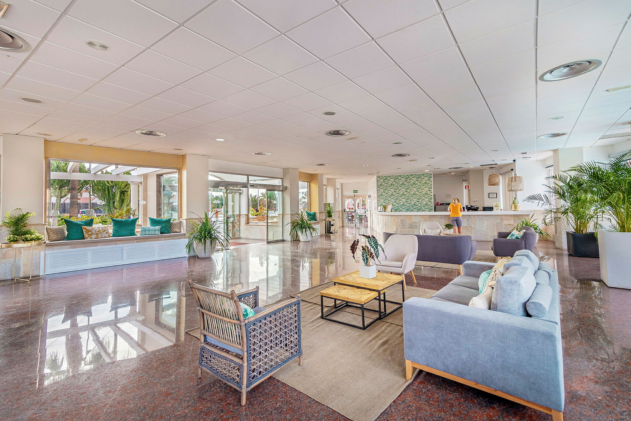 Hotellobby med sittgrupper, reception och dekorativa växter. (AI-genererad text)