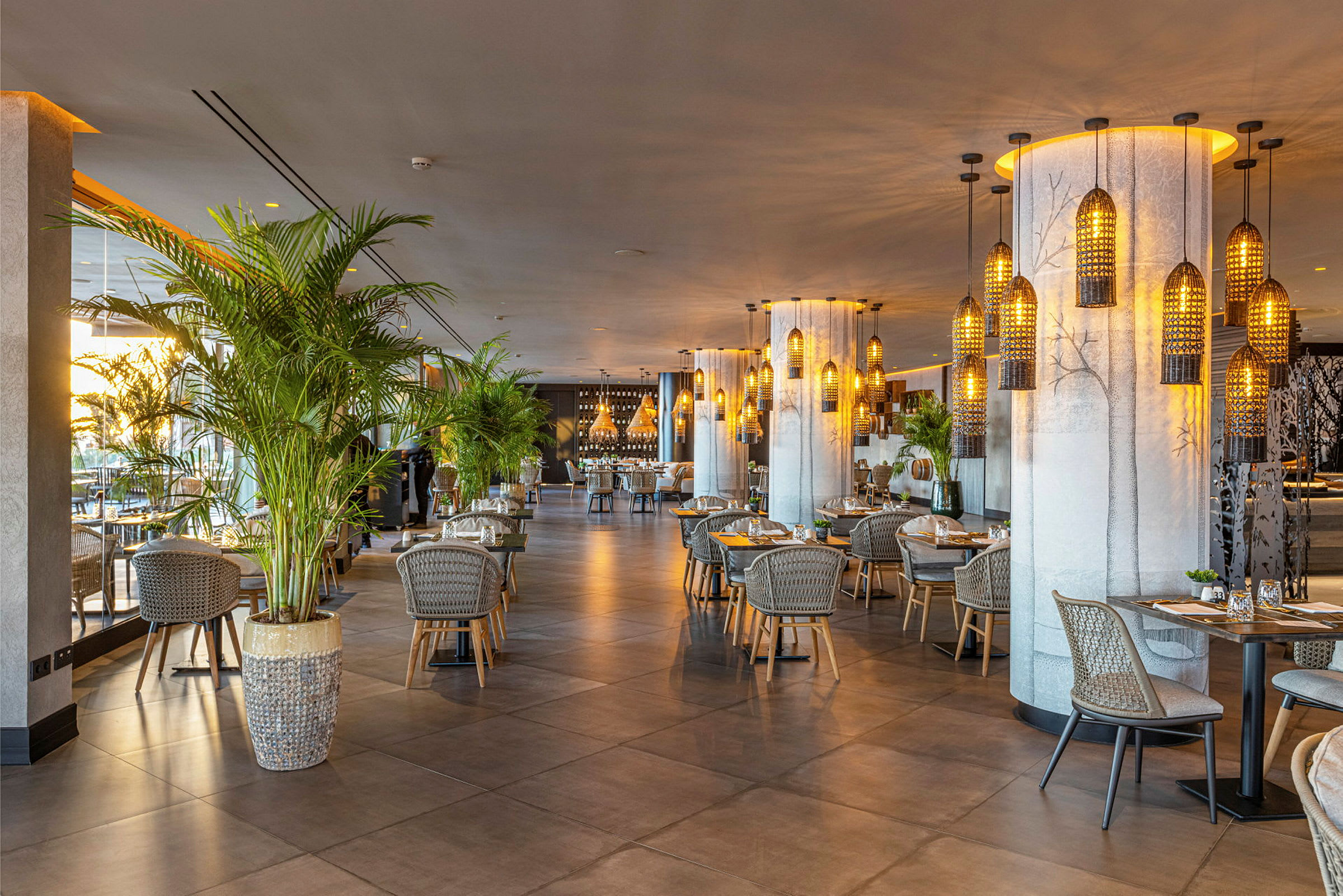 En modern restaurang med bord och stolar, omgiven av dekorationer och växter. (AI-genererad text)