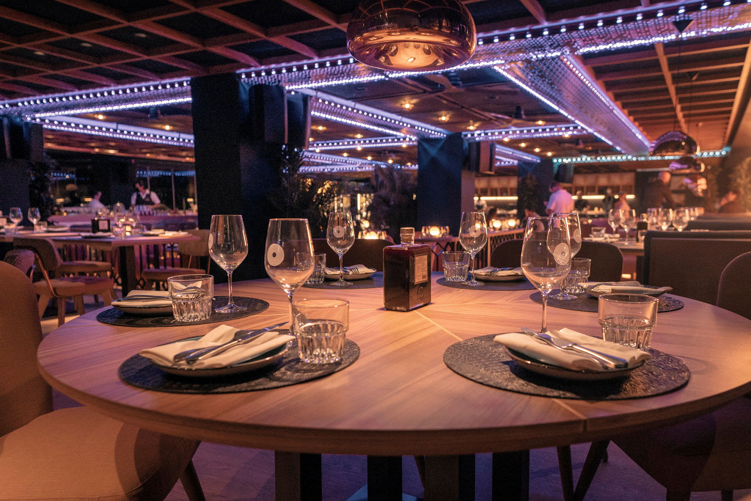 En restaurang med dukade bord, glas och servetter. (AI-genererad text)