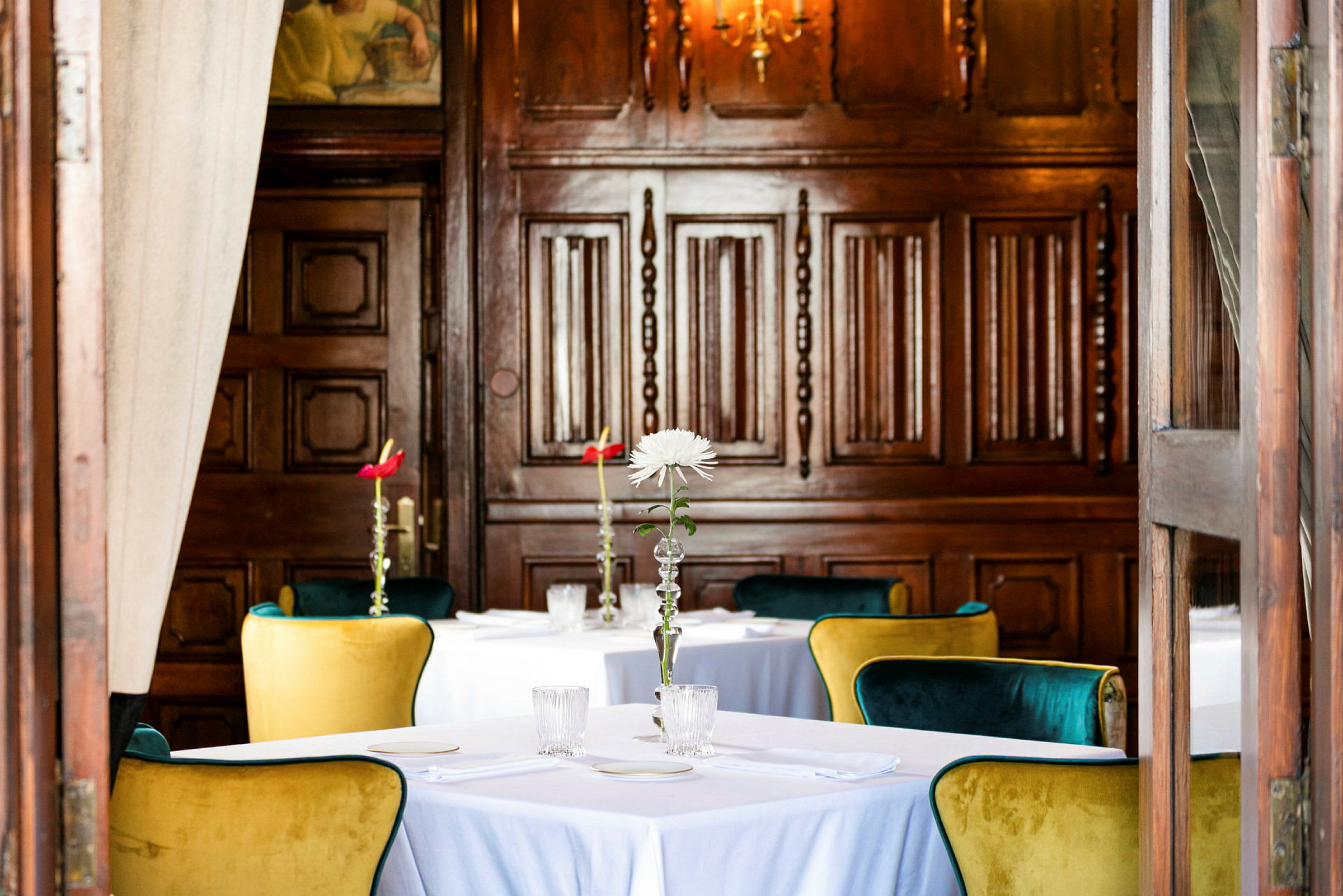 Elegant restaurang med dukade bord och detaljer i trä. (AI-genererad text)