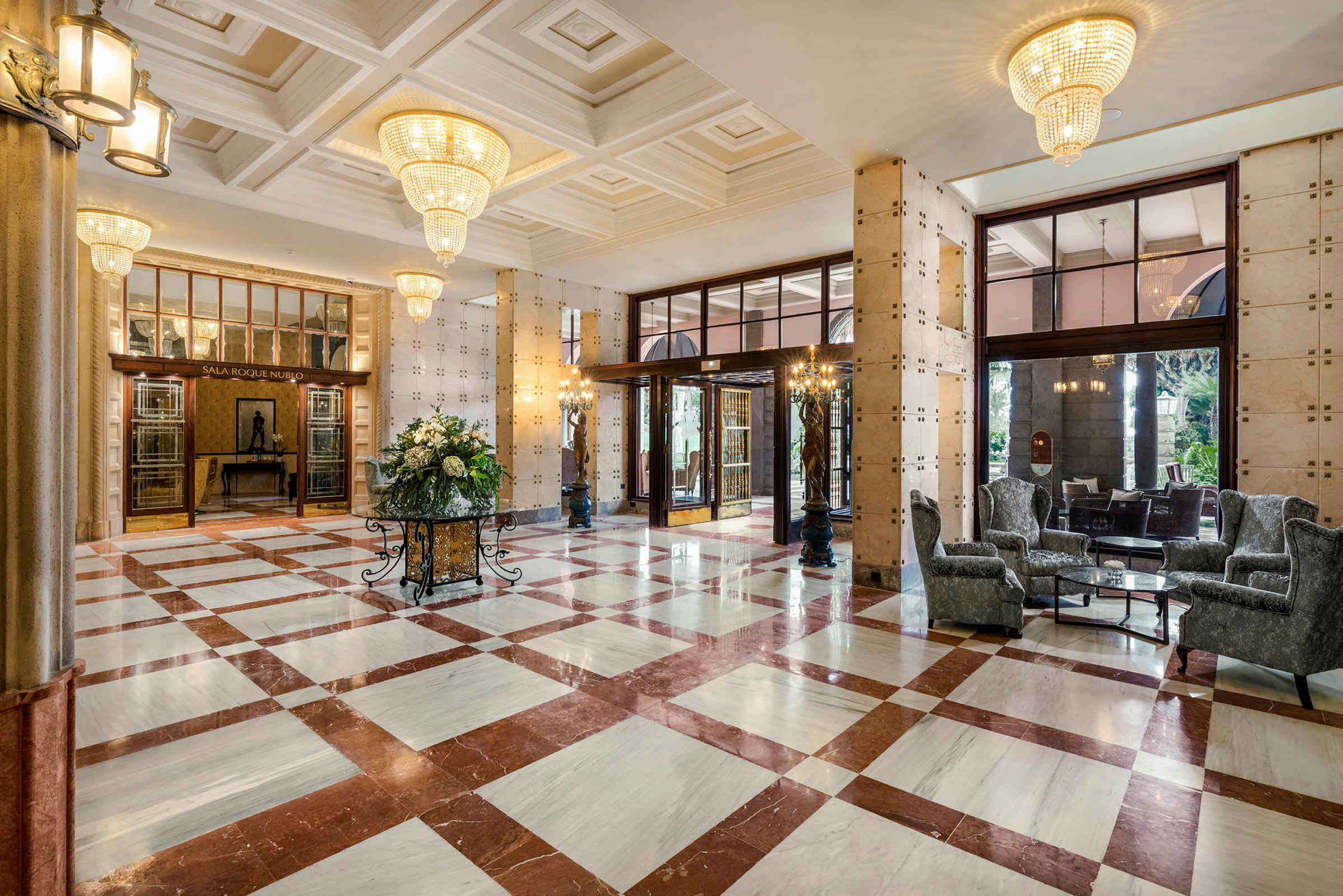 Elegant hotellobby med marmorgolv, stora girlander och sittmöbler. (AI-genererad text)