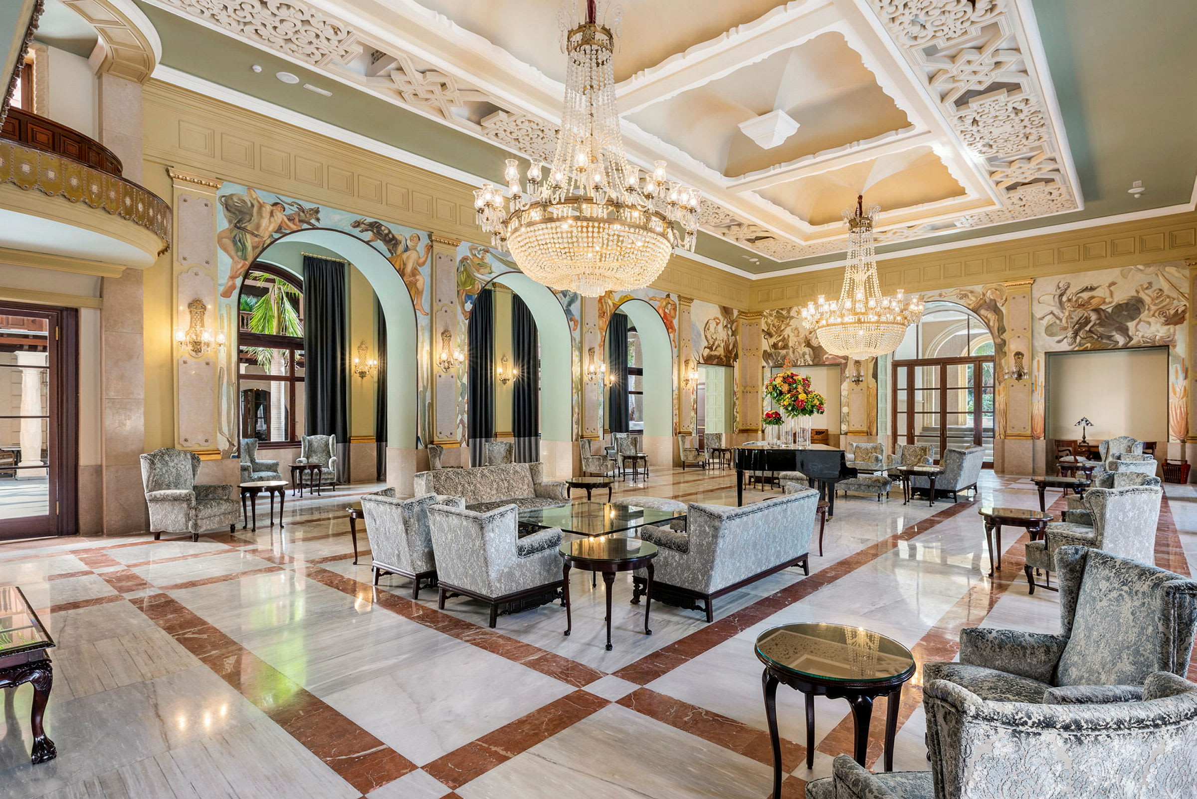 Ett vackert hotell med elegant lobby, sittplatser och kristallkronor. (AI-genererad text)
