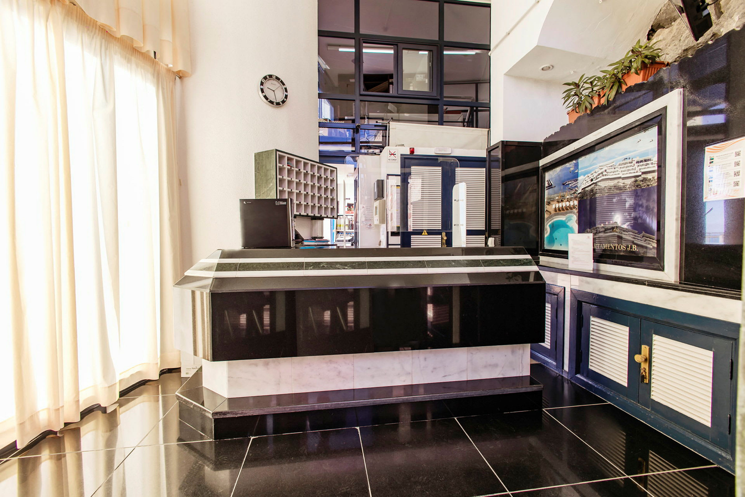 Reception vid ett hotell med svart och vit inredning. (AI-genererad text)