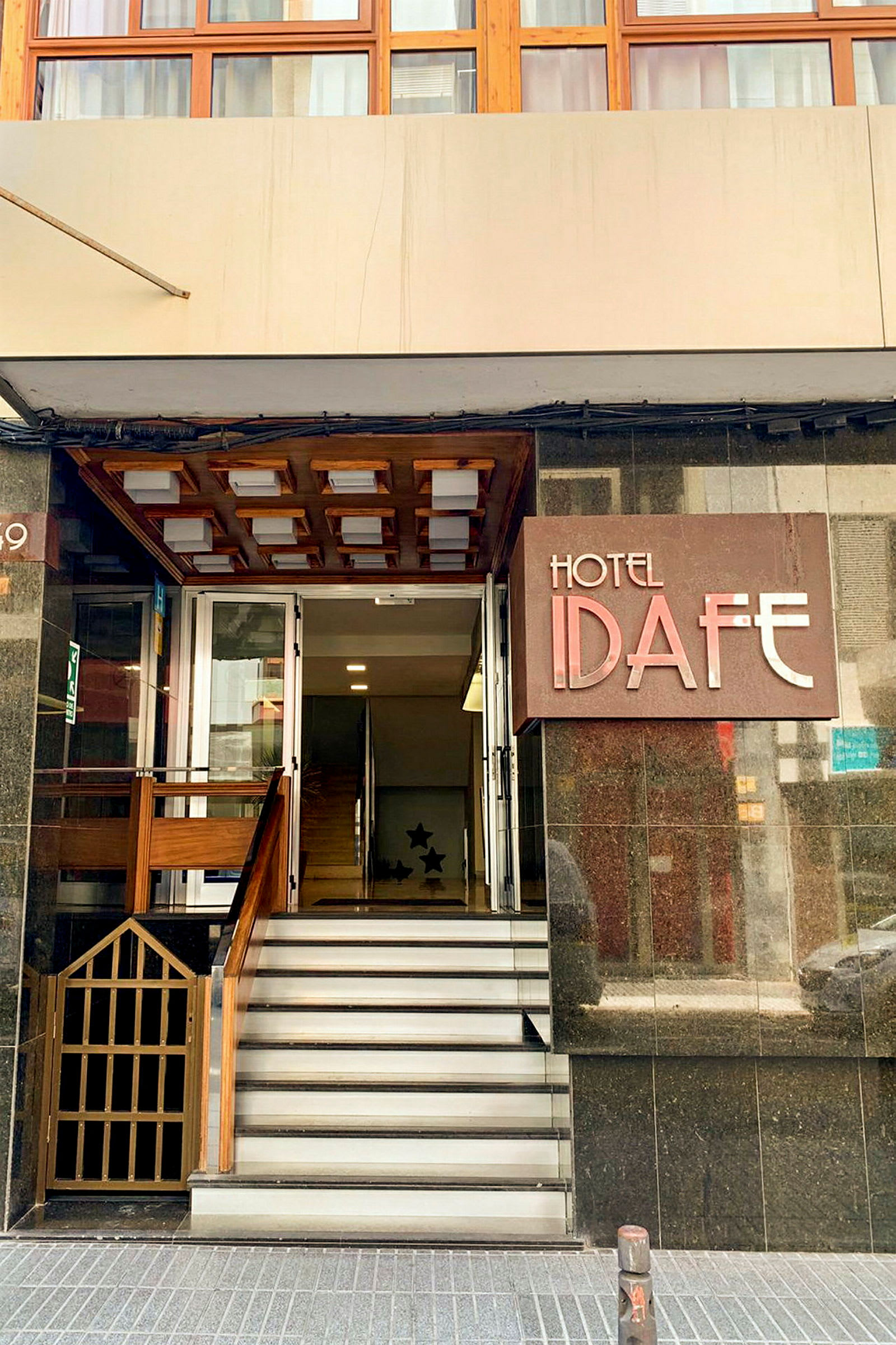 Entrén till Hotel Idafe med några trappsteg och en dörr. (AI-genererad text)