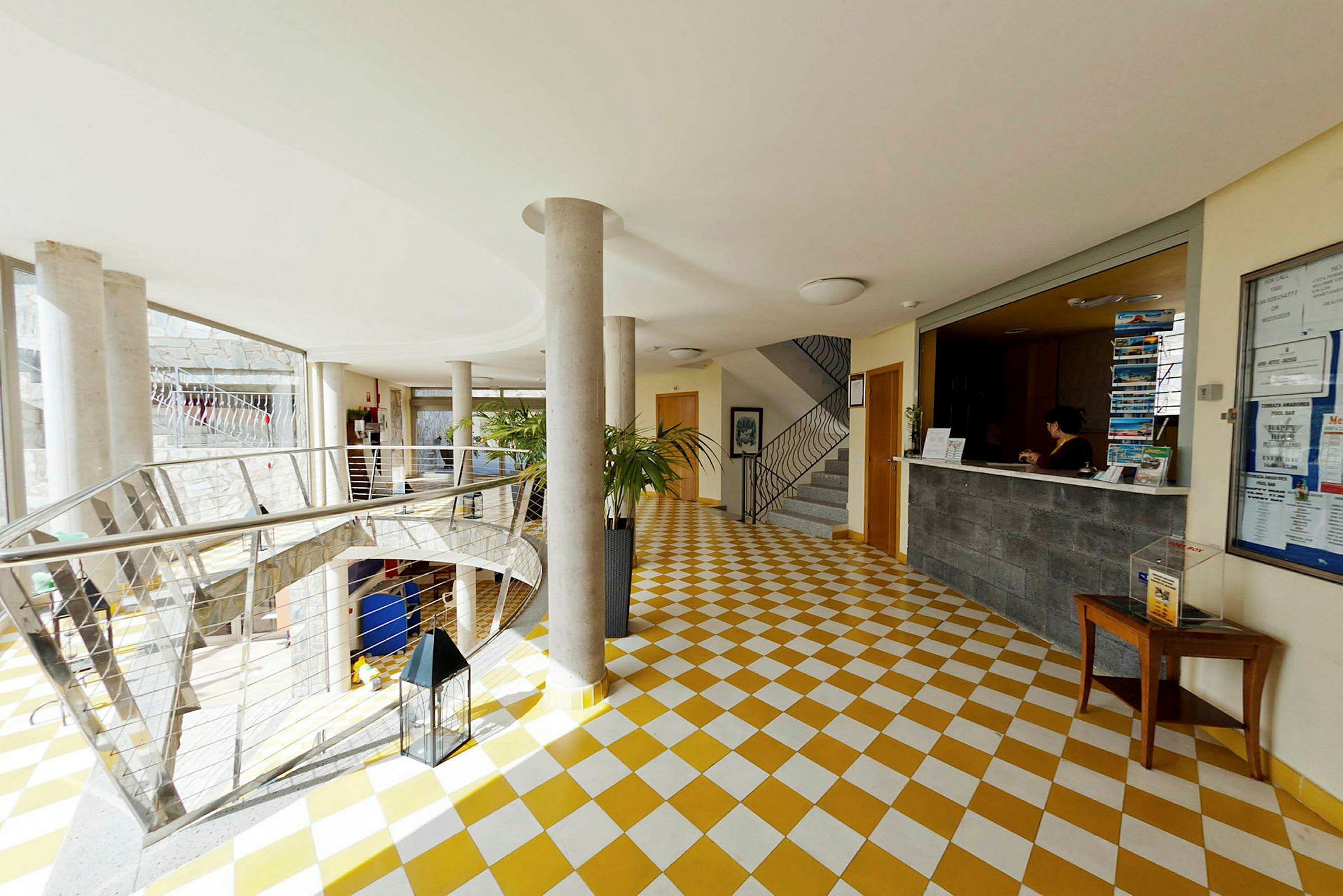 Lobby med reception och trappor i en byggnad. (AI-genererad text)