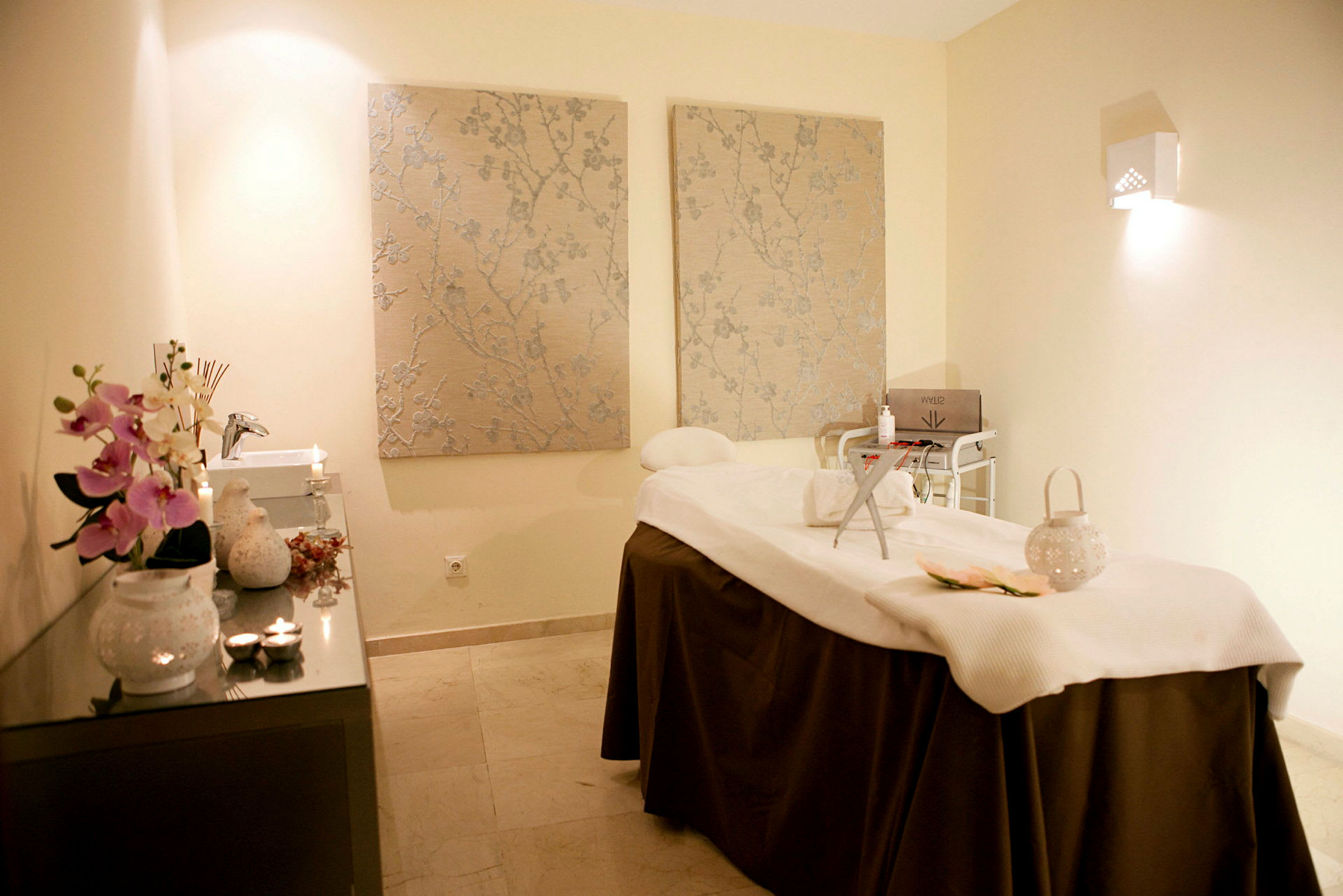 Ett välkomnande massage- och spabehandlingsrum med upplyst inredning och dekorativa element. (AI-genererad text)