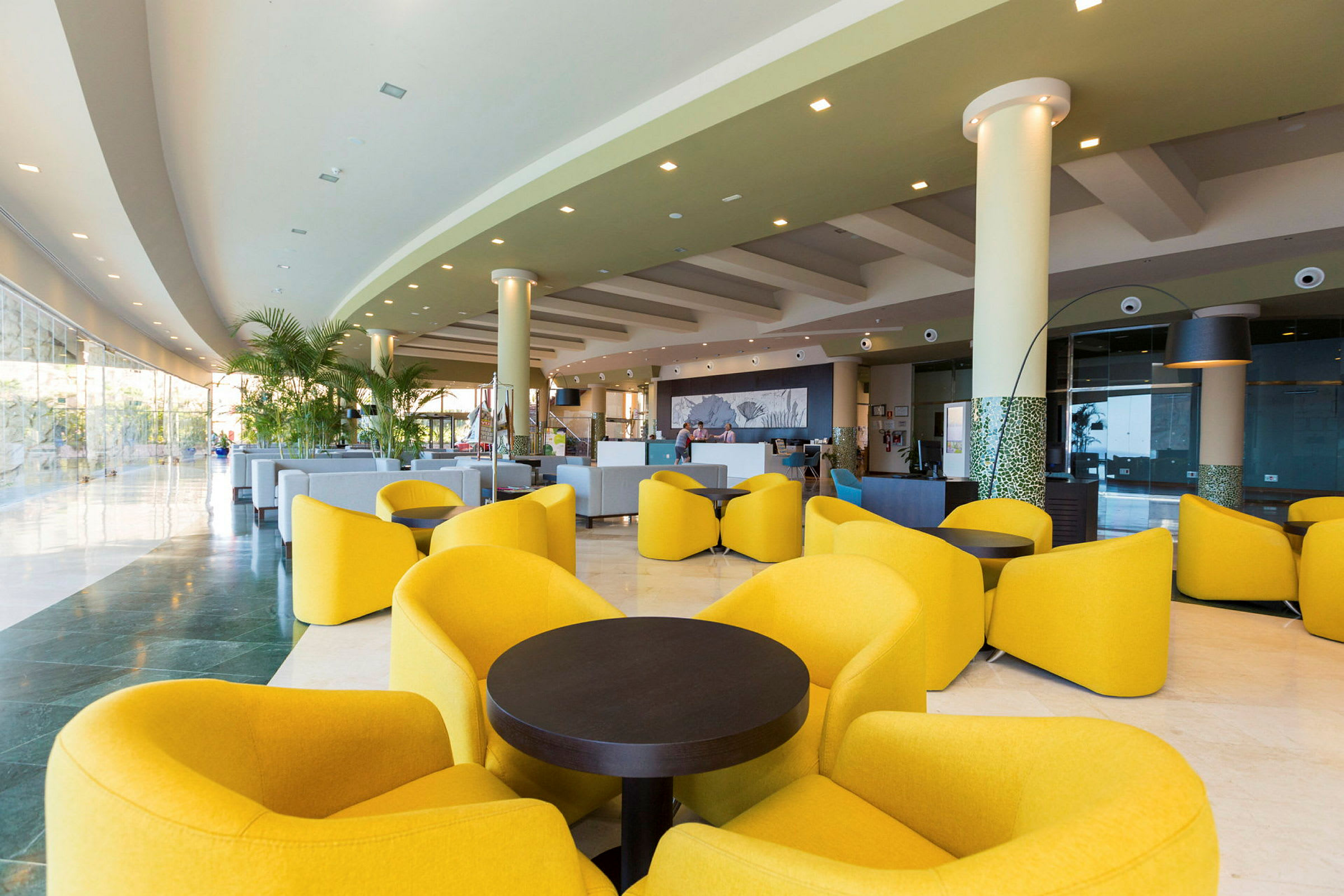 Interiör av en modern hotellobby med gula loungestolar och soffor. (AI-genererad text)