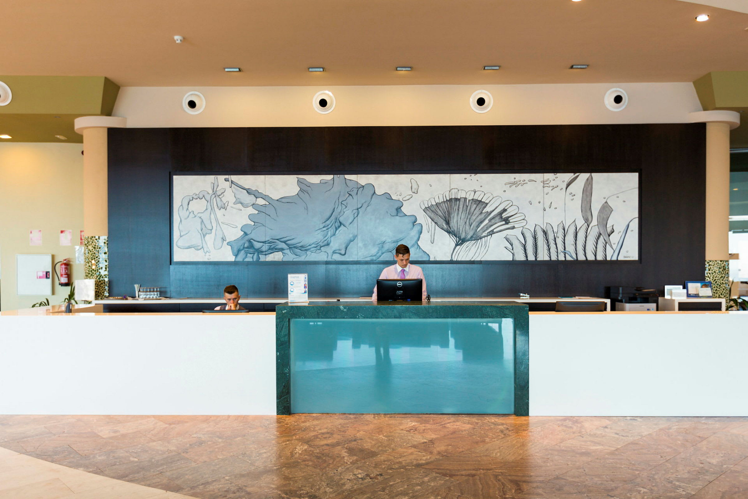 Hotellets reception med en modern inredning och en dekorativ väggmålning. (AI-genererad text)