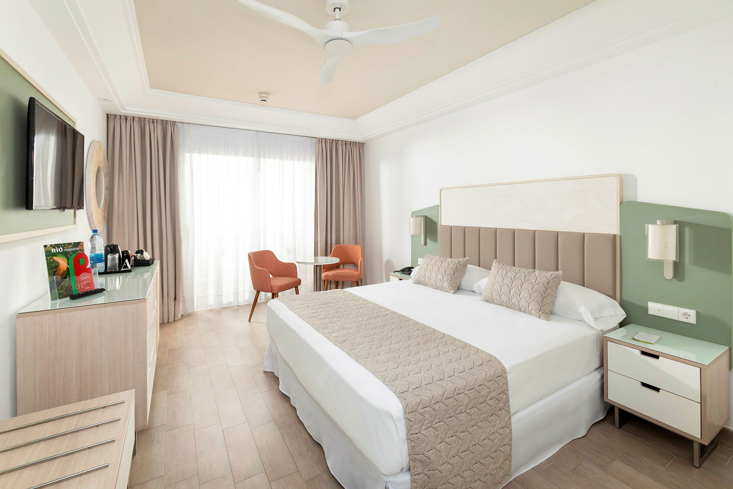 Hotellrum med dubbelsäng, tv, sittgrupp och garderob. (AI-genererad text)