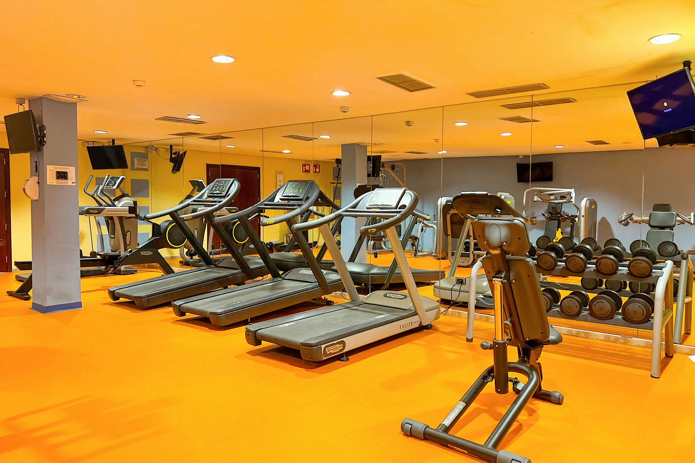 Ett gym med träningsutrustning som löpband, hantlar och maskiner. (AI-genererad text)
