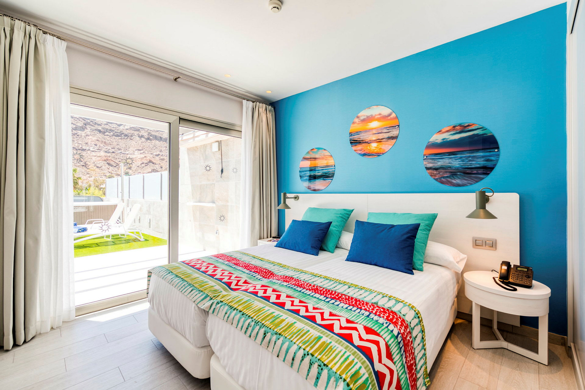 Modernt hotellrum med färgstark inredning och utsikt över terrass. (AI-genererad text)