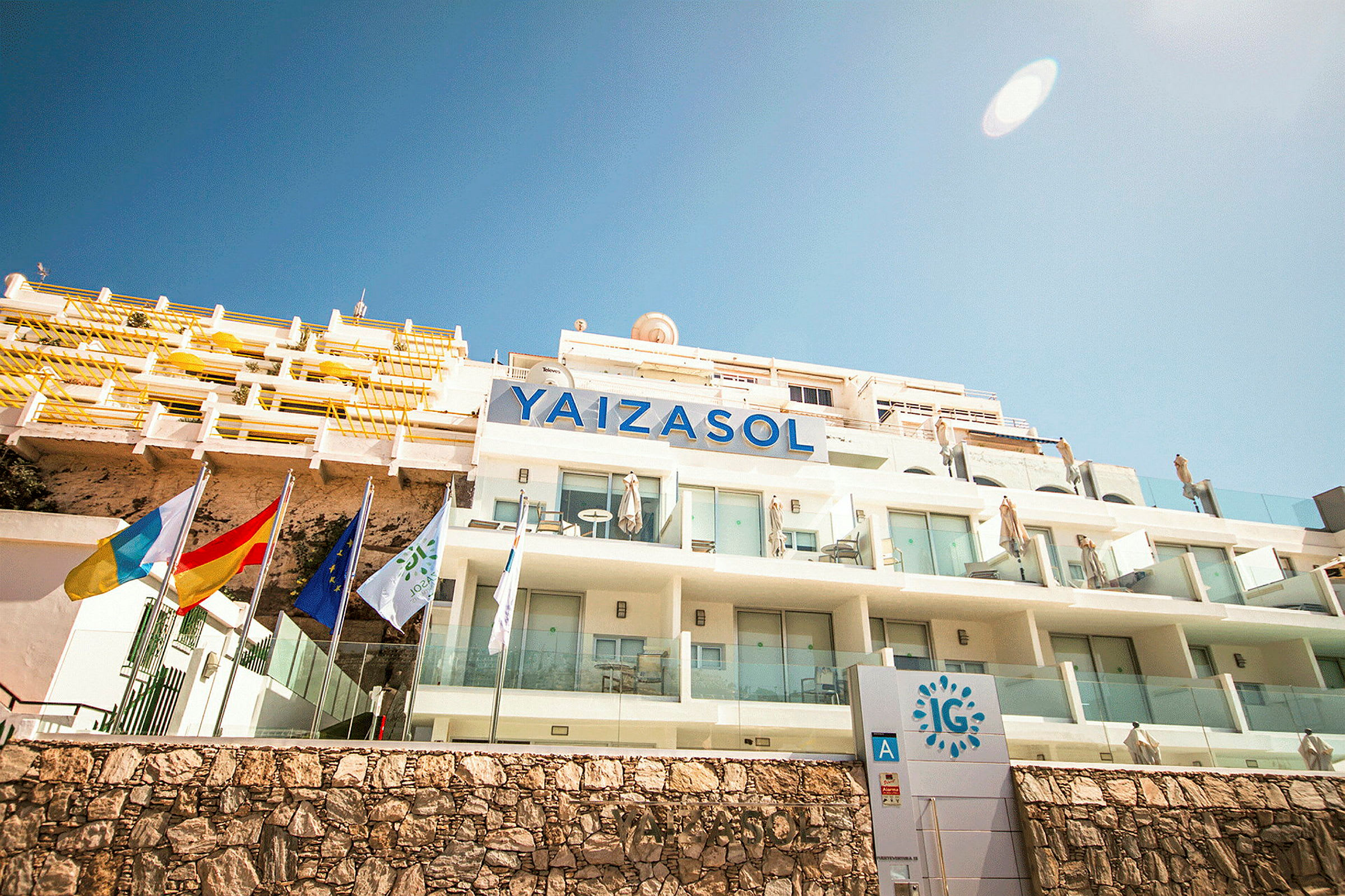 Bild på hotellbyggnaden Yaizasol med balkonger och flaggor. (AI-genererad text)