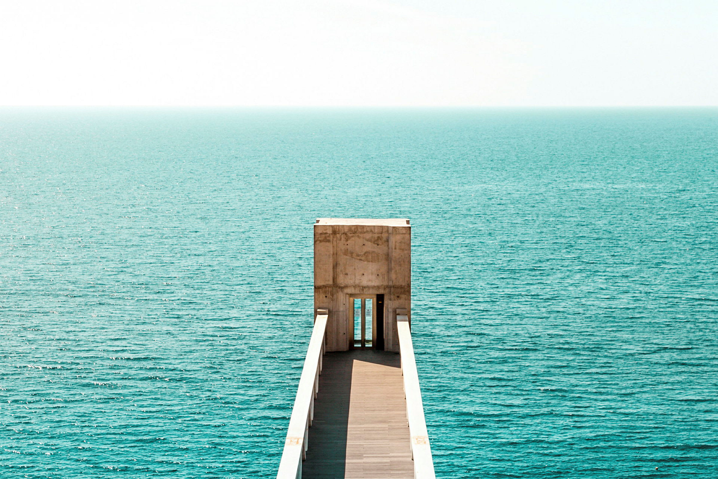 En brygga som leder ut mot havet under klar himmel. (AI-genererad text)