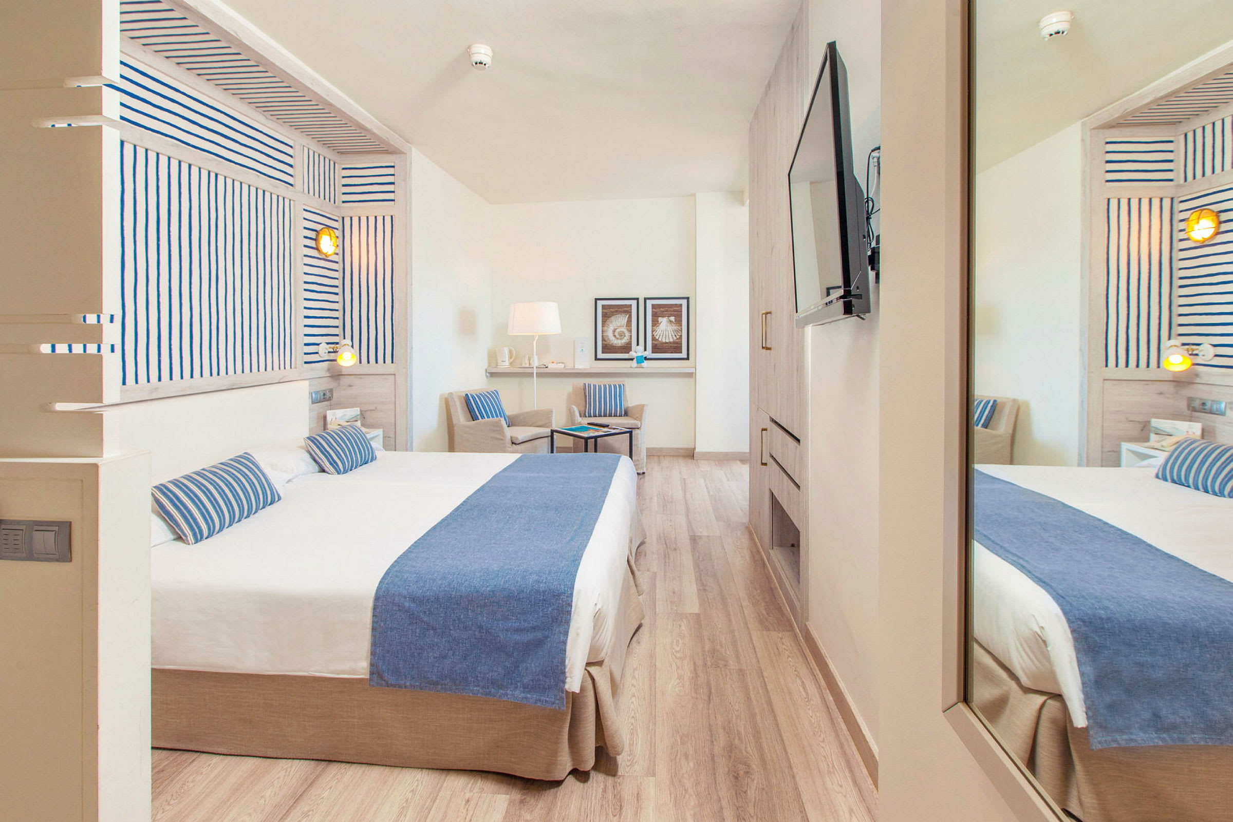 Hotellrum med dubbelsäng och stol, inrett i en ljus och modern stil. (AI-genererad text)