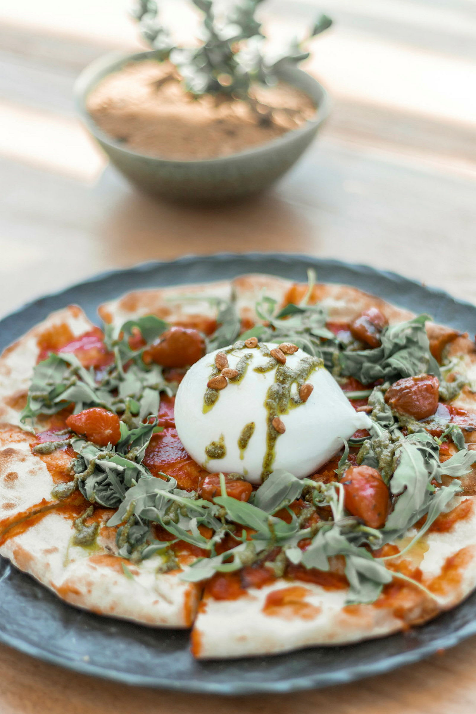En maträtt med burrata och grönsaker på en botten. (AI-genererad text)